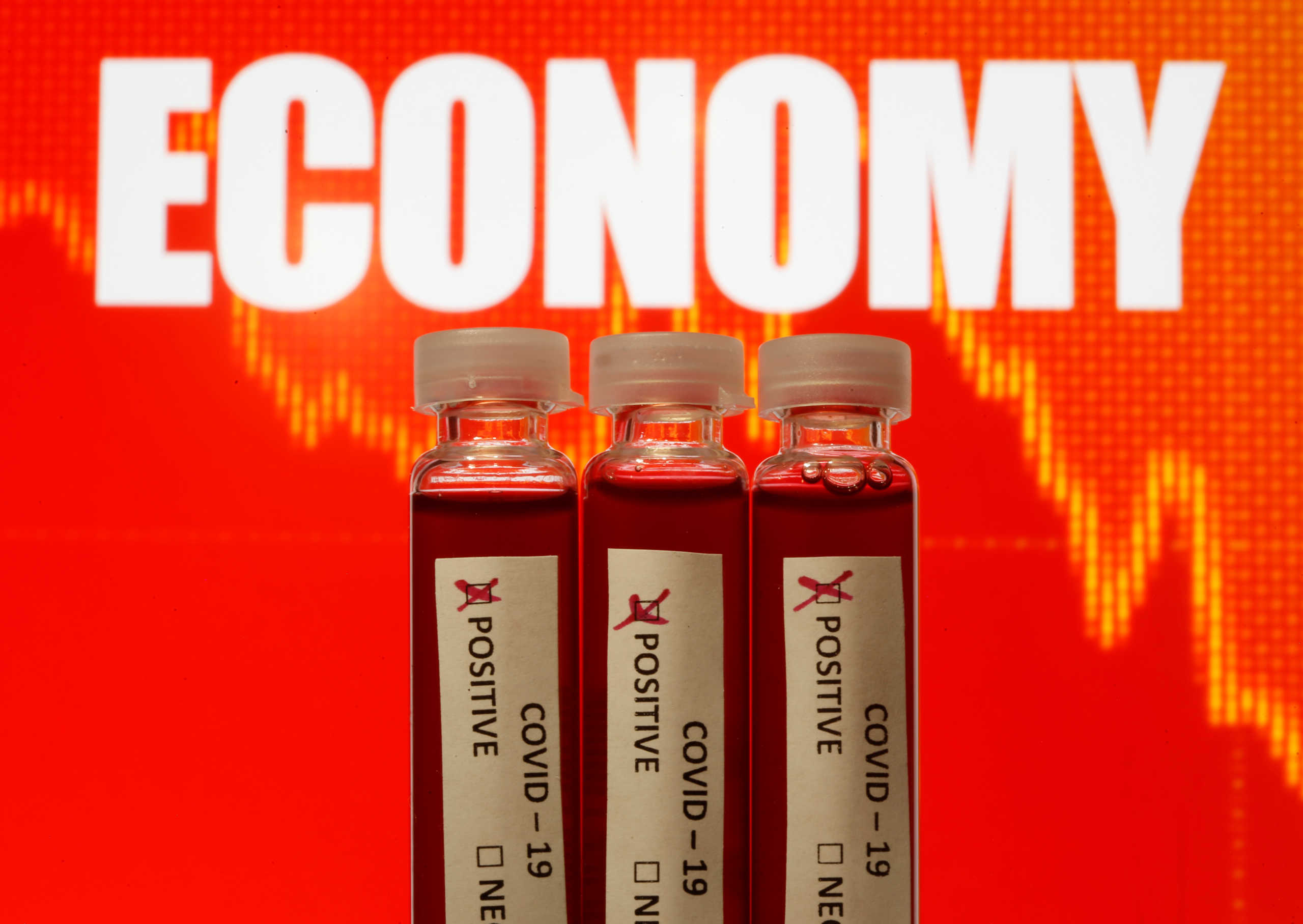 Fake blood is seen in test tubes labelled with the coronavirus (COVID-19) in front of the word "Economy" in this illustration taken March 11, 2020. REUTERS