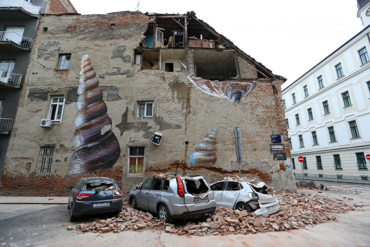 Damaged cars and a partially damaged building are seen following an earthquake, in Zagreb, Croatia March 22, 2020. REUTERS