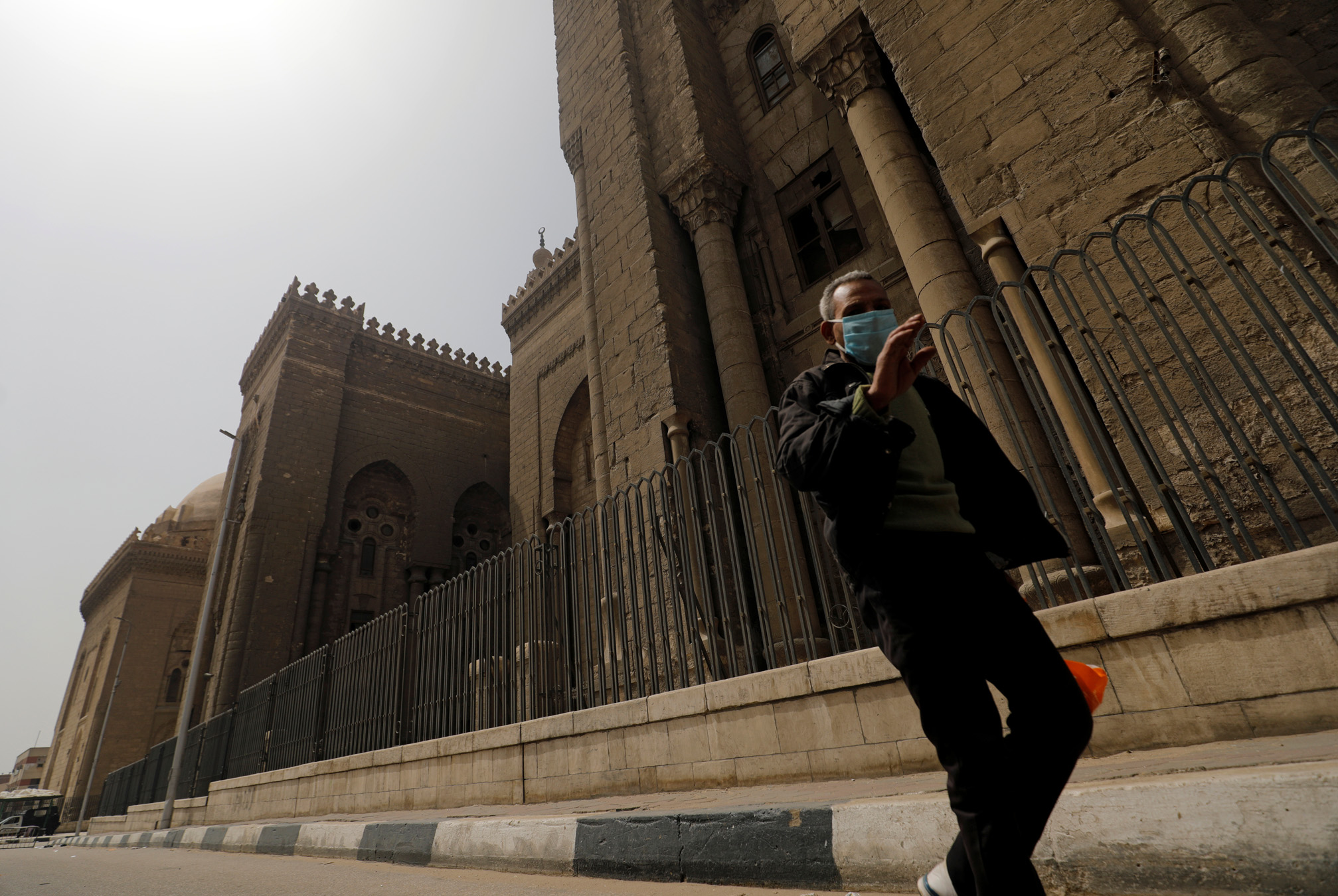 A man wearing a face mask walks past Al-Rifa'i Mosque, as muslims did not attend Friday prayers due to the spread of coronavirus disease (COVID-19), in old Islamic Cairo, Egypt, March 27, 2020. REUTERS