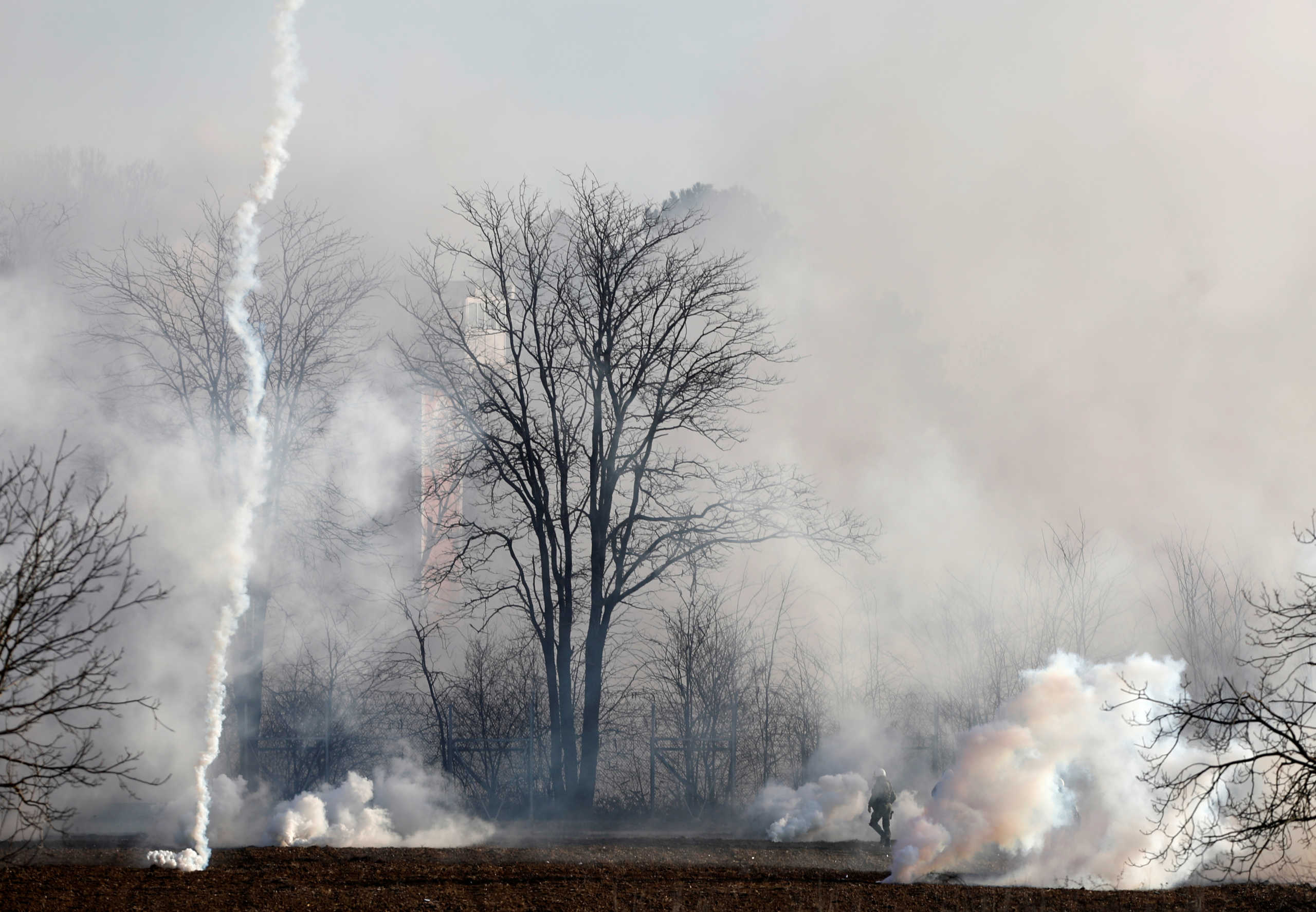 A Greek riot police officer stands guard as tear gas is being fired near Turkey's Pazarkule border crossing, in Kastanies, Greece March 6, 2020. REUTERS