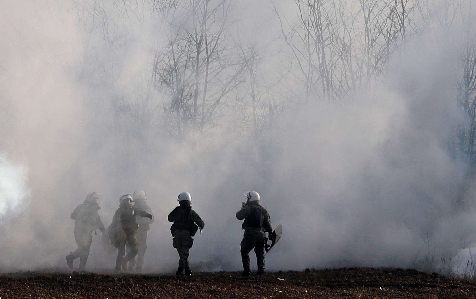 Greek riot police officers walk amid clouds of tear gas near Turkey's Pazarkule border crossing, in Kastanies, Greece March 6, 2020. REUTERS