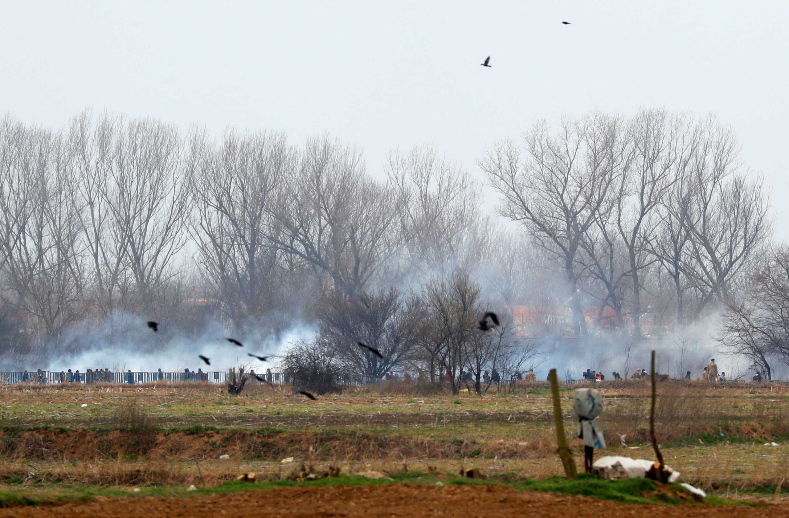 Tear gas floats in the air as migrants walk towards the Turkey's Pazarkule border crossing with Greece's Kastanies, near Edirne, Turkey, March 4, 2020. REUTERS