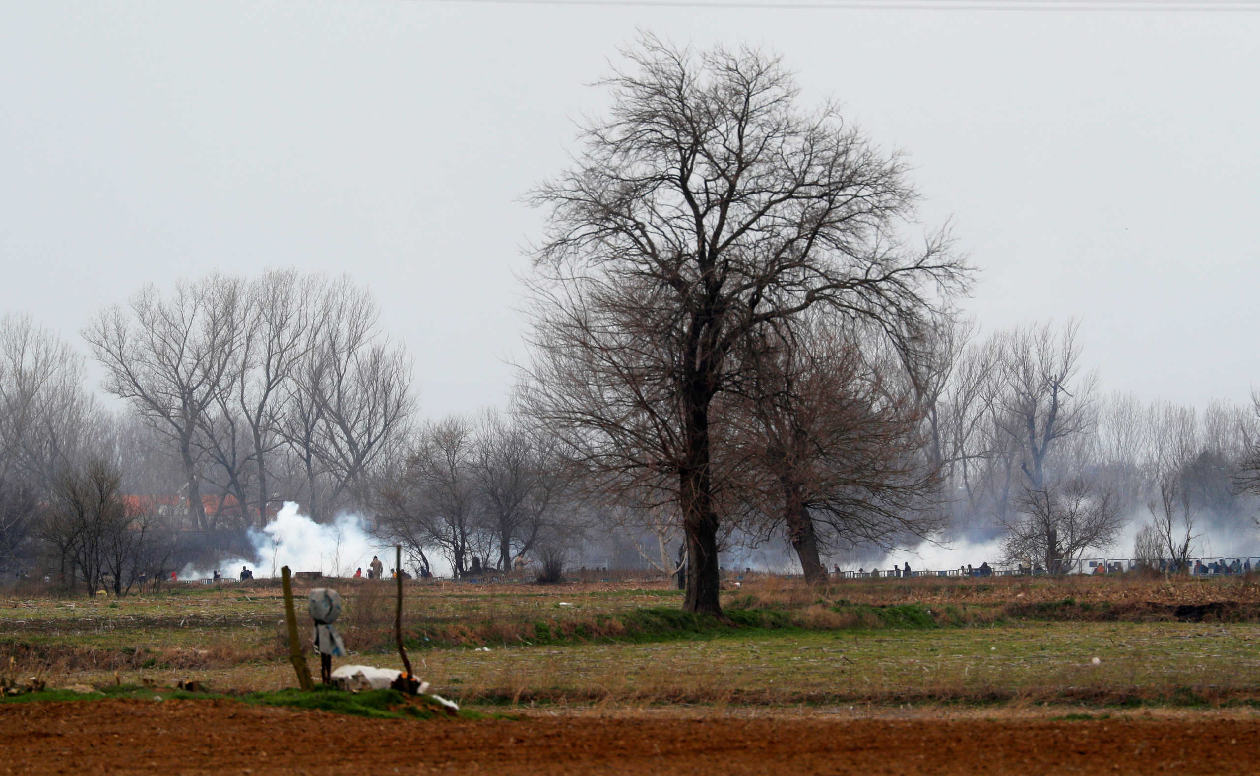 Tear gas floats in the air as migrants walk towards the Turkey's Pazarkule border crossing with Greece's Kastanies, near Edirne, Turkey, March 4, 2020. REUTERS