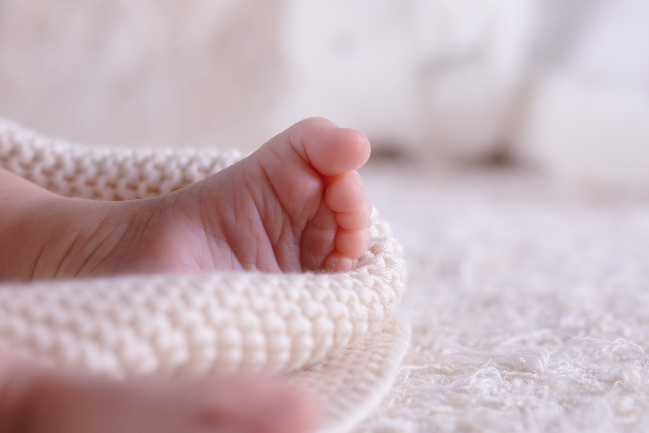 New Born Baby Feet on White Blanket