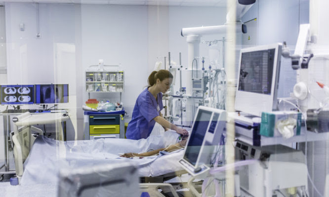 Doctor using electrode on patient in operating theatre.