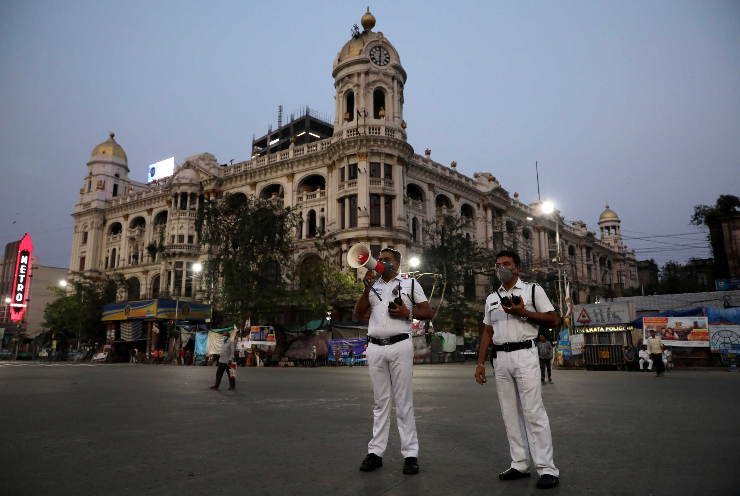 A police officer uses a megaphone advising people to vacate the roads after the lockdown by West Bengal state government to limit the spreading of coronavirus disease (COVID-19), in Kolkata, India March 23, 2020. REUTERS