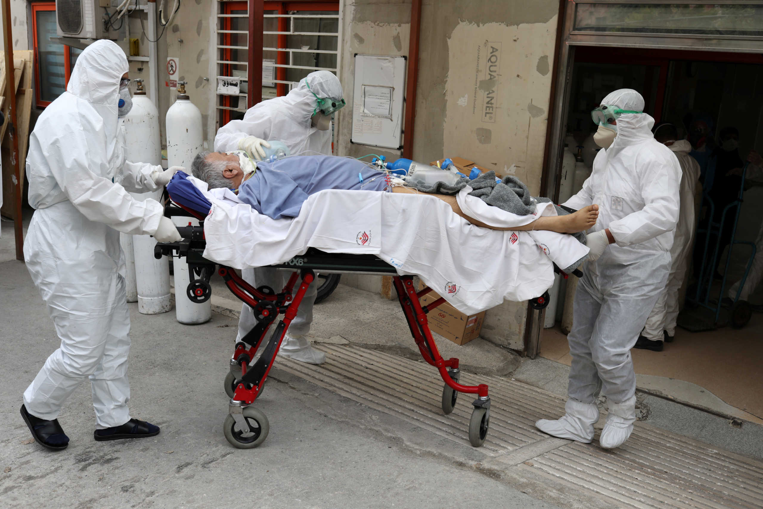 Emergency medical staff wearing protective suits, transfer a patient with coronavirus disease (COVID-19) to Masih Daneshvari Hospital, in Tehran, Iran March 30, 2020. WANA (West Asia News Agency)