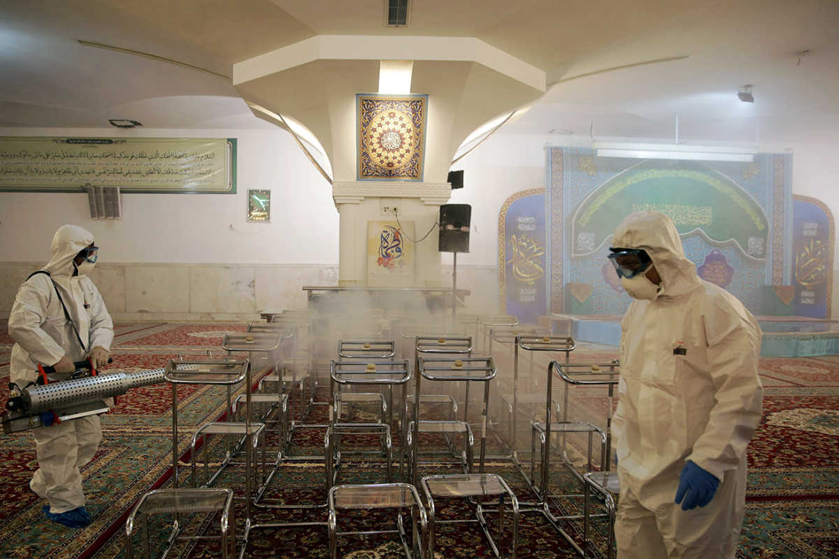 FILE PHOTO: Members of a medical team spray disinfectant to sanitize indoor place of Imam Reza's holy shrine, following the coronavirus outbreak, in Mashhad, Iran February 27, 2020. Picture taken February 27, 2020. WANA (West Asia News Agency) via REUTERS ATTENTION EDITORS - THIS PICTURE WAS PROVIDED BY A THIRD PARTY