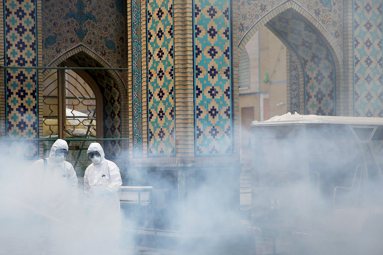 FILE PHOTO: Members of the medical team spray disinfectant to sanitize outdoor place of Imam Reza's holy shrine, following the coronavirus outbreak, in Mashhad, Iran February 27, 2020. WANA (West Asia News Agency) via REUTERS ATTENTION EDITORS - THIS PICTURE WAS PROVIDED BY A THIRD PARTY