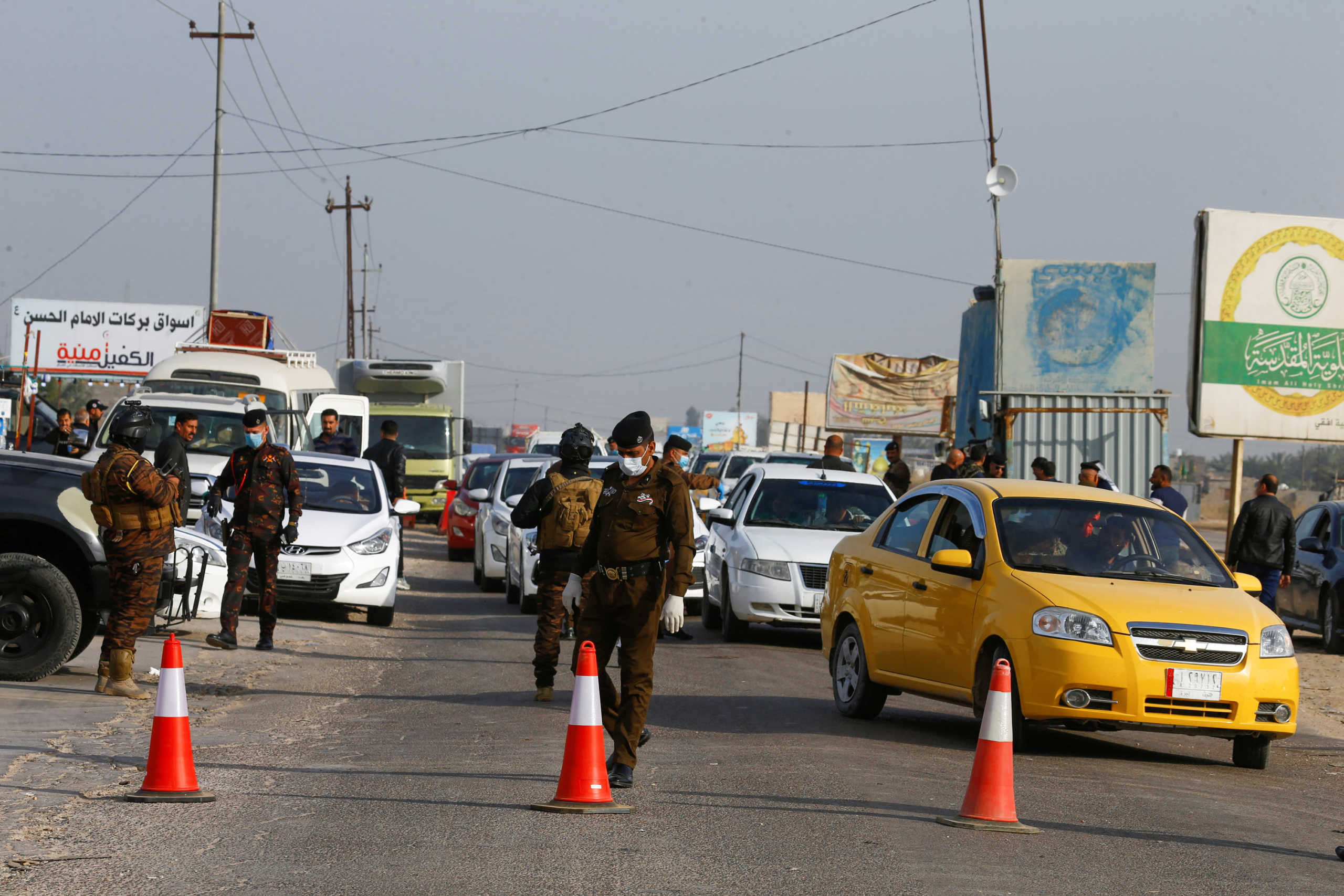 Members of Iraqi security forces wear masks in one of the main streets, where they prevent visitors from entering the city, after Iraq's Najaf authorities banned all non-residents visits, following the outbreak of coronavirus, in the holy city of Najaf, Iraq March 11, 2020. REUTERS