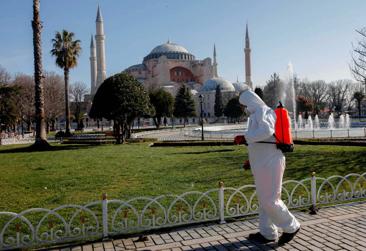 A worker in protective suit disinfects Sultanahmet square in response to the spread of coronavirus disease (COVID-19) in Istanbul,Turkey March 21, 2020. Byzantine-era monument of Hagia Sophia is seen in the background. REUTERS