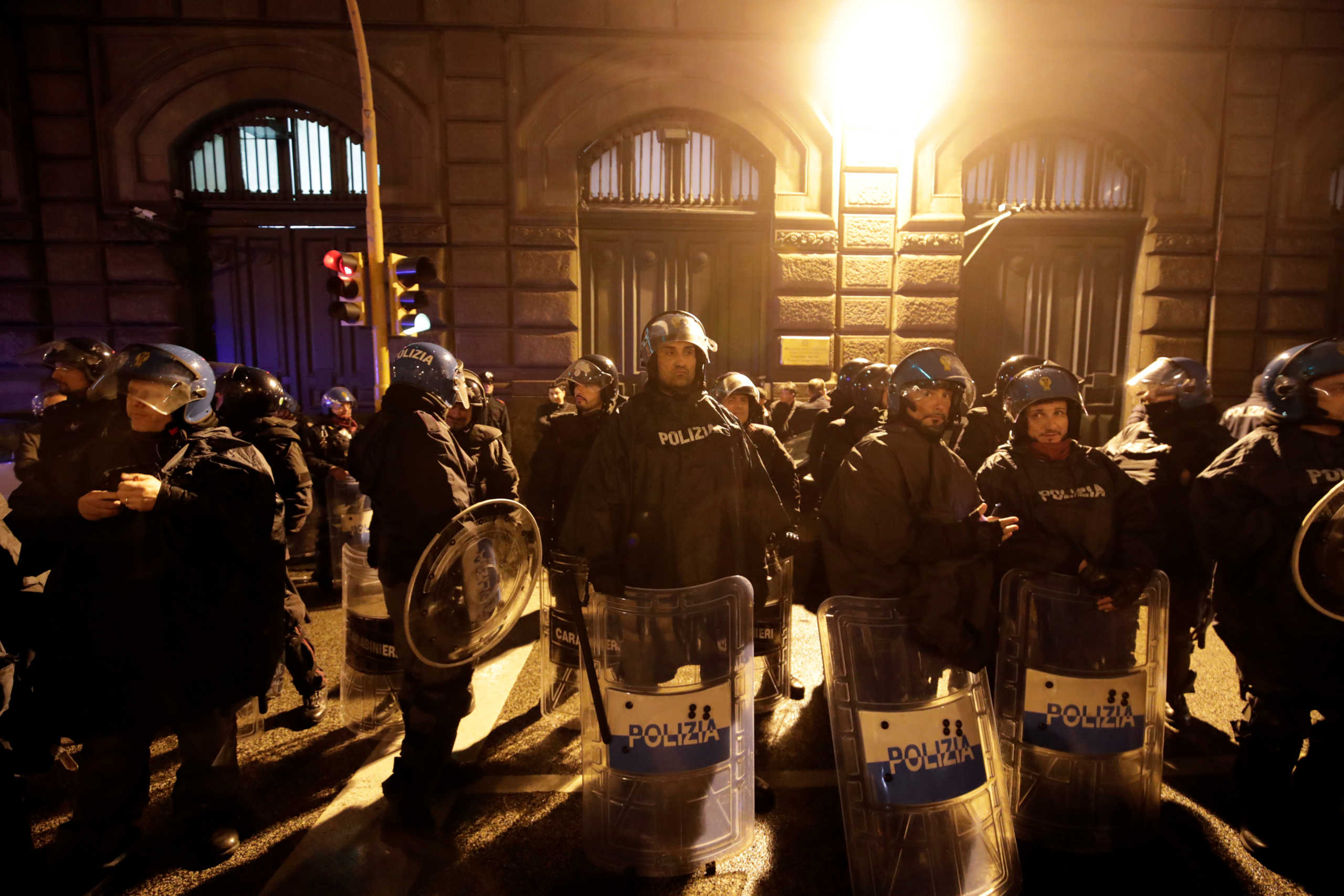 Police officers stand guard as relatives of inmates gather outside Poggioreale prison in Naples, Italy, March 8, 2020. REUTERS