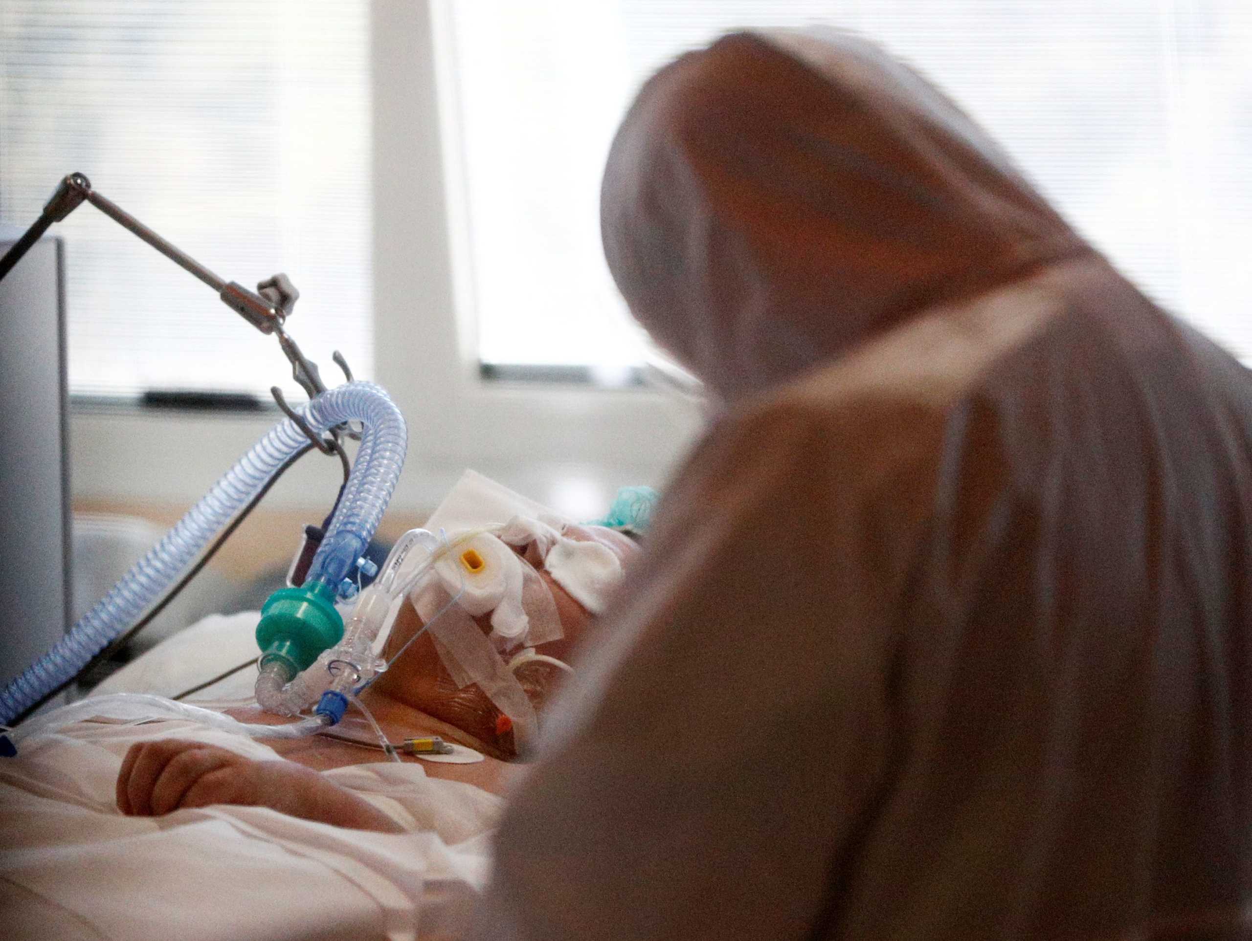 A medical worker in a protective suit treats a patient suffering with coronavirus disease (COVID-19) in an intensive care unit at the Casalpalocco hospital, a hospital in Rome that has been dedicated to treating cases of the disease, Italy, March 24, 2020. REUTERS