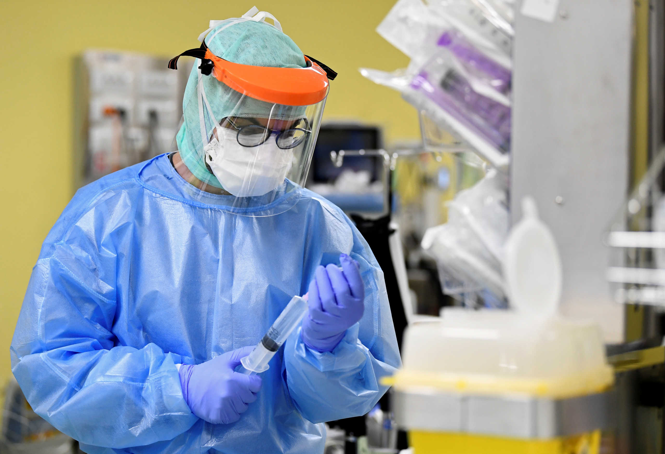 A member of the medical staff in a protective suit treats a patient suffering from coronavirus disease (COVID-19) in an intensive care unit at the San Raffaele hospital in Milan, Italy, March 27, 2020. REUTERS