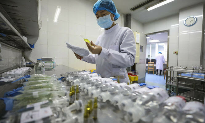 In this Sunday, Feb. 16, 2020, photo, a nurse prepares medicines for patients at Jinyintan Hospital designated for new coronavirus infected patients, in Wuhan in central China's Hubei province. China reported thousands new virus cases and more deaths in its update Tuesday, Feb. 18, 2020 on a disease outbreak that has caused milder illness in most people, an assessment that promoted guarded optimism from global health authorities. (Chinatopix via AP)
