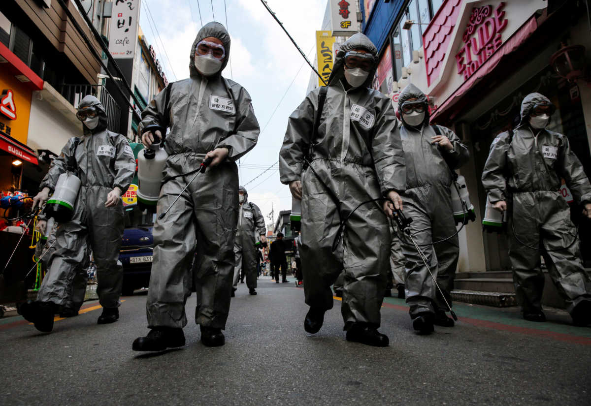 South Korean soldiers in protective gear sanitize?a shopping street in Seoul, South Korea, March 4, 2020.    REUTERS