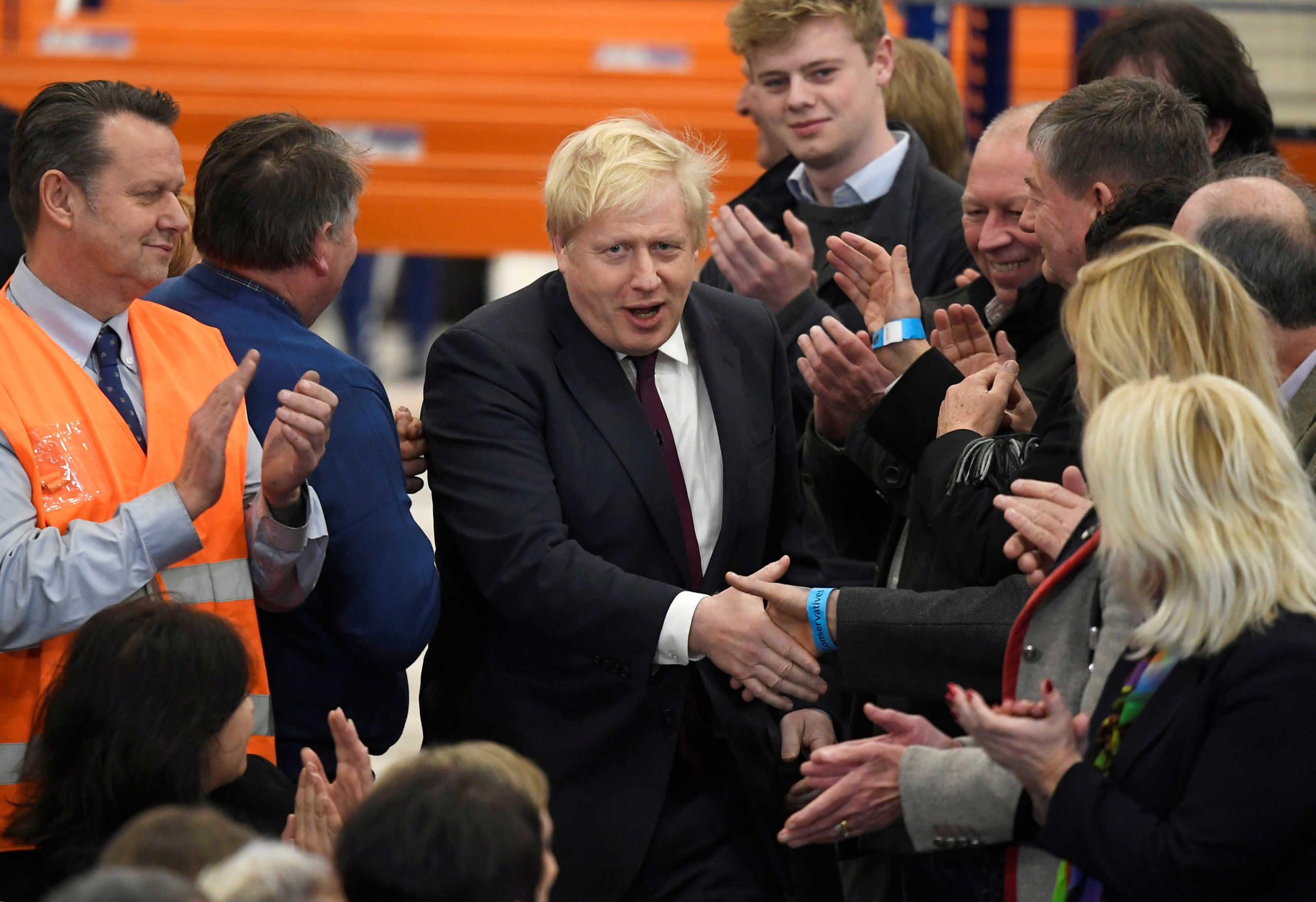 FILE PHOTO: Britain's Prime Minister Boris Johnson shakes hands with members of the audience as he visits a JCB factory during his general election campaign in Uttoxeter, Britain, December 10, 2019.  REUTERS