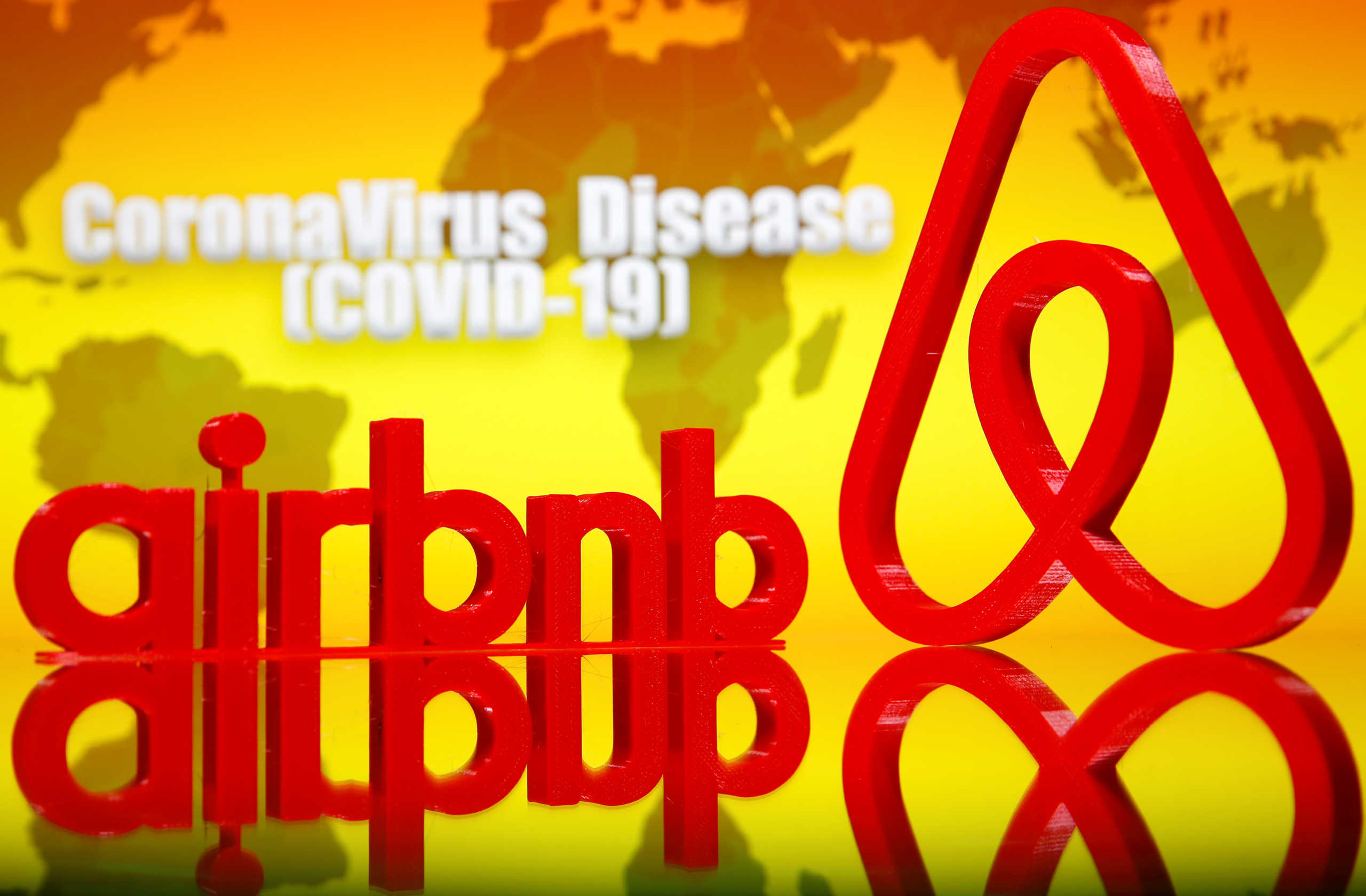 A 3D printed Airbnb logo is seen in front of displayed coronavirus disease (COVID-19) writing in this illustration taken, March 23, 2020. Picture taken March 23, 2020. REUTERS