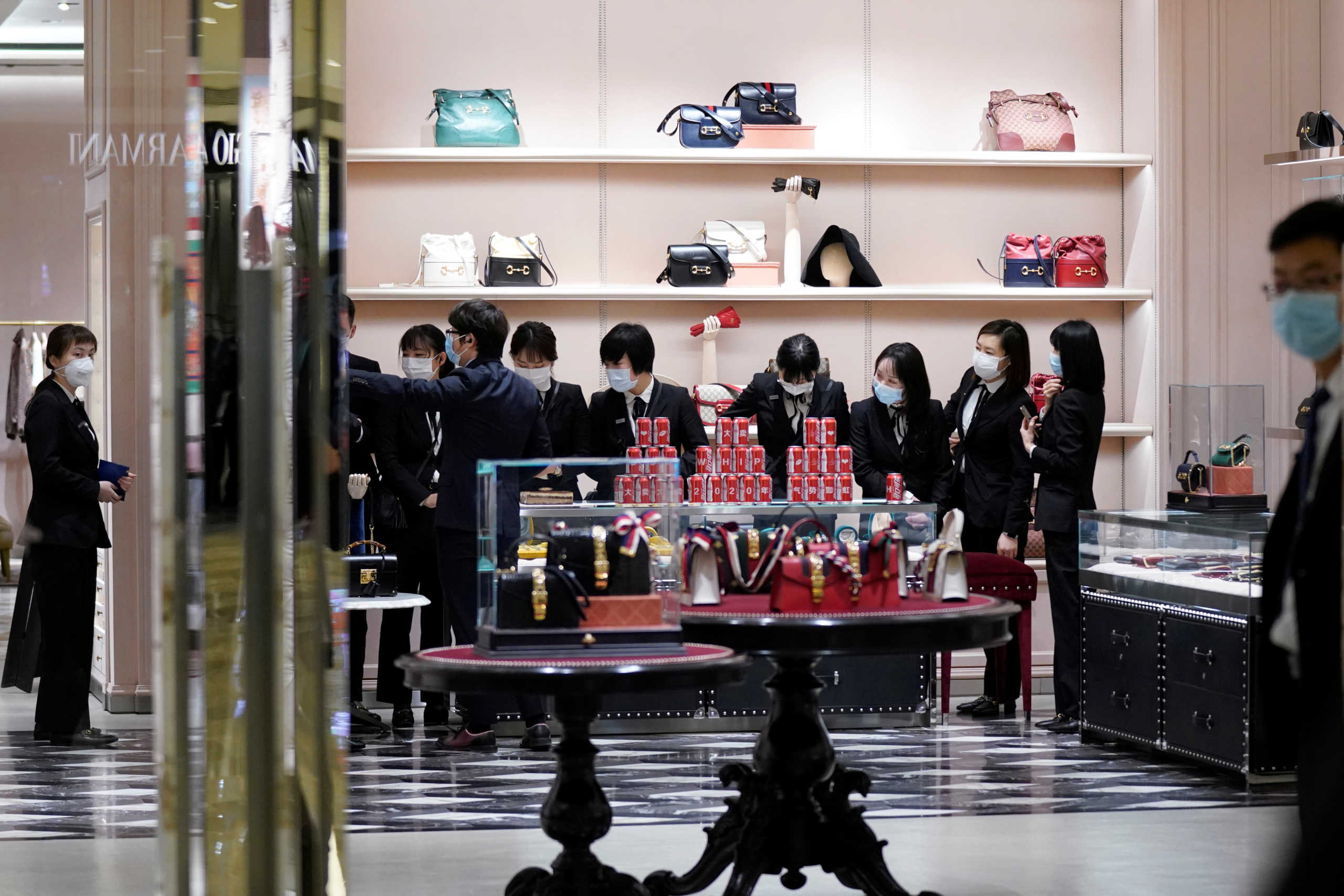 Staff members wearing face masks get ready for a ceremony before a Gucci store inside a shopping mall opens in Wuhan, Hubei province, the epicentre of China's coronavirus disease (COVID-19) outbreak, March 30, 2020. REUTERS