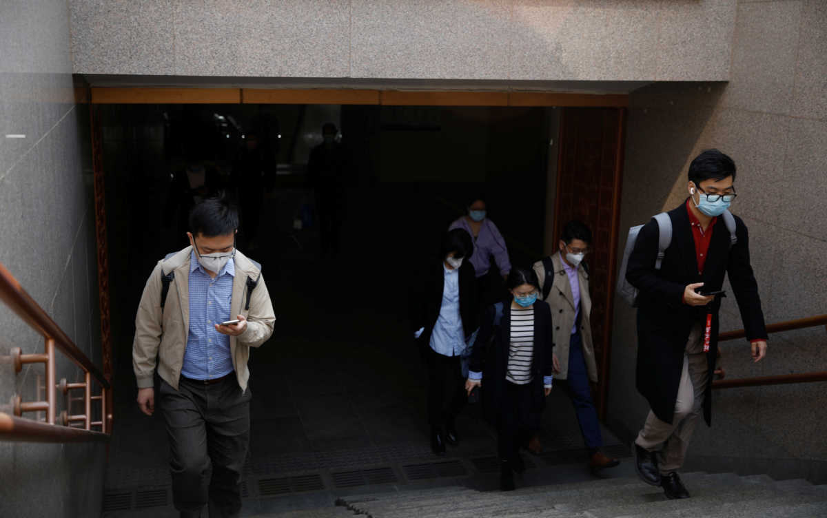 People wearing face masks exit a subway station following an outbreak of the coronavirus disease (COVID-19), in Beijing, China March 30, 2020. REUTERS