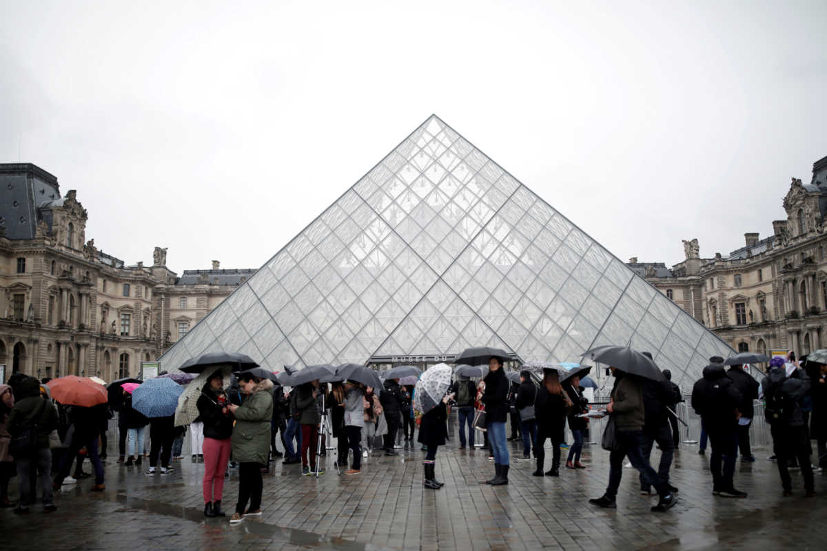 FILE PHOTO: Tourists queue to enter the Louvre as the staff closed the museum during a staff meeting about the coronavirus outbreak, in Paris, France, March 2, 2020. REUTERS