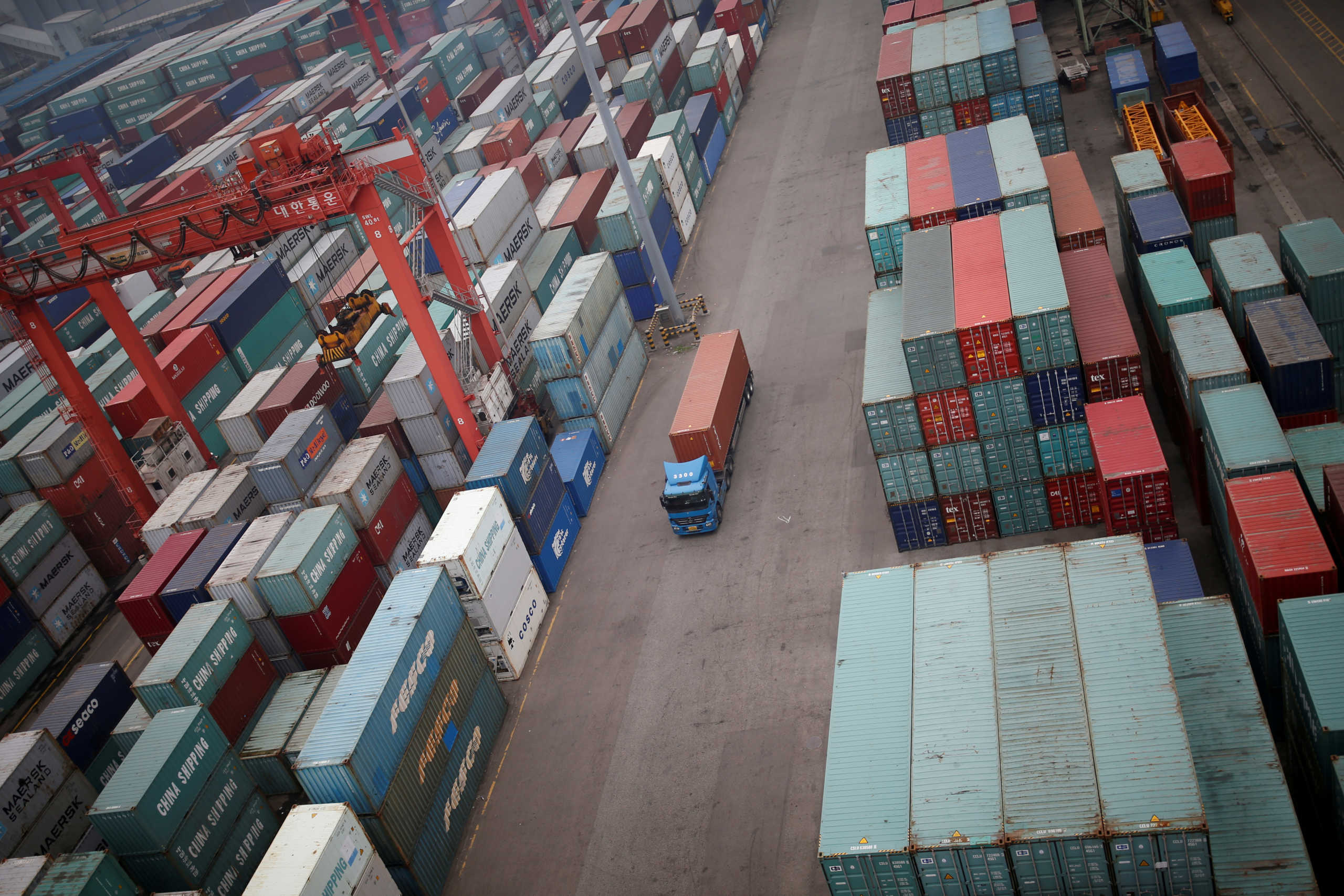 FILE PHOTO: A truck drives between shipping containers at a container terminal at Incheon port in Incheon, South Korea, May 26, 2016.REUTERS