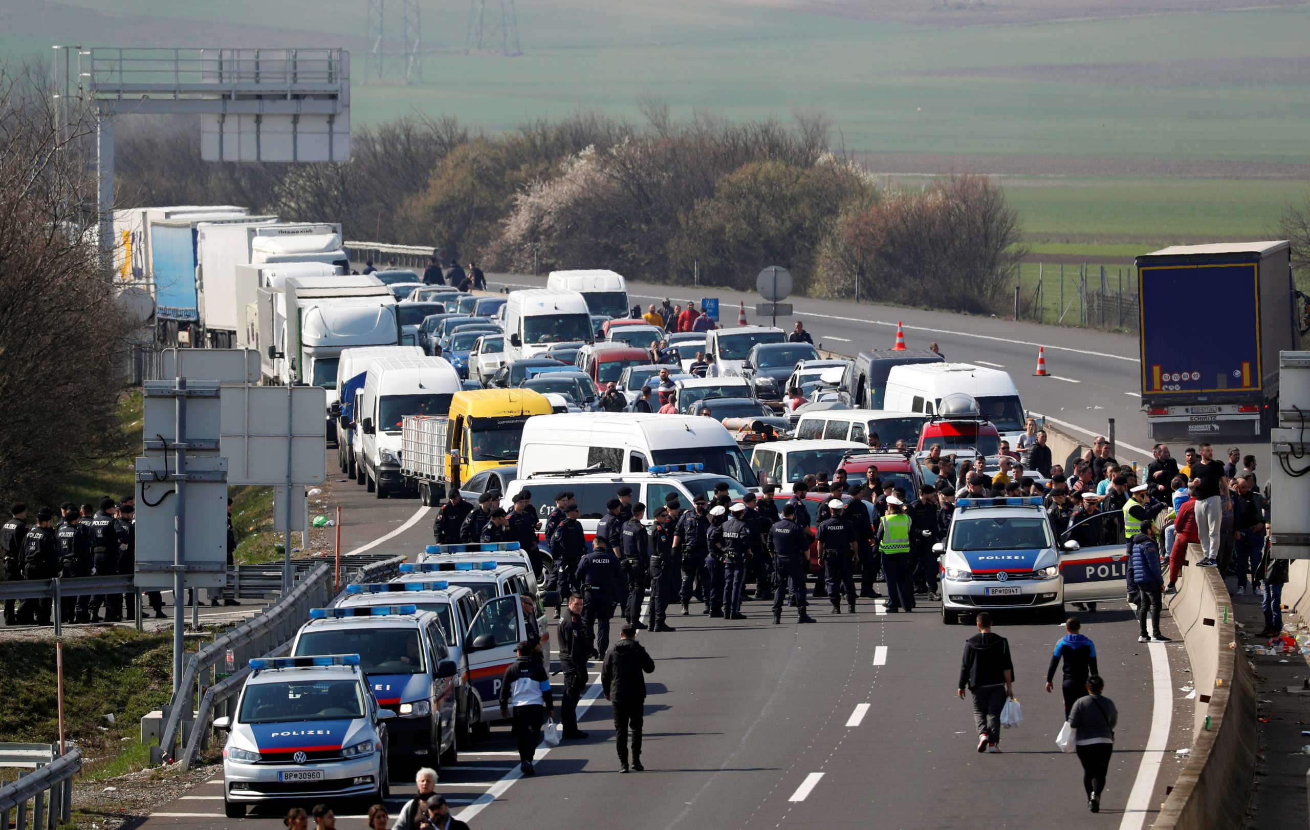 People and police officers gather while the Hungarian-Austrian border is closed, as the spread of the coronavirus disease (COVID-19) continues, near Nickelsdorf, Austria, March 18, 2020. REUTERS