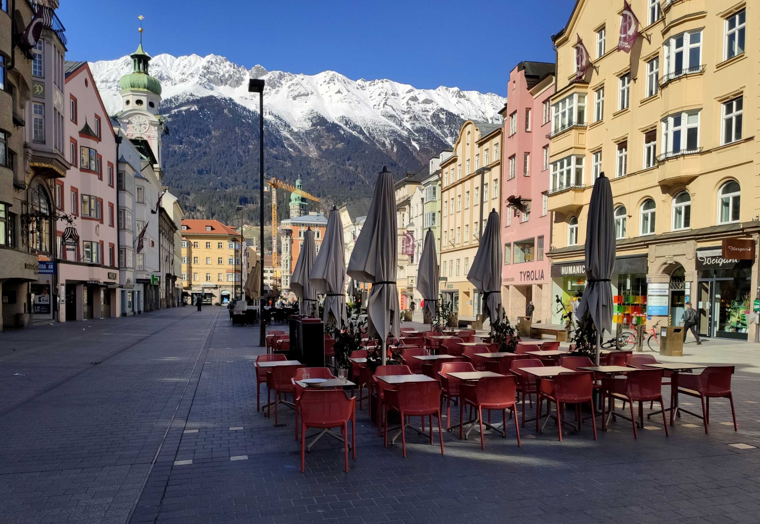 Empty tables of a cafe are seen at Maria-Theresien-Strasse pedestrian area in front of Nordkette mountains after the government announced a curfew on the Austrian province of Tyrol amid growing coronavirus disease (Covid-19), in Innsbruck, Austria March 15, 2020. REUTERS