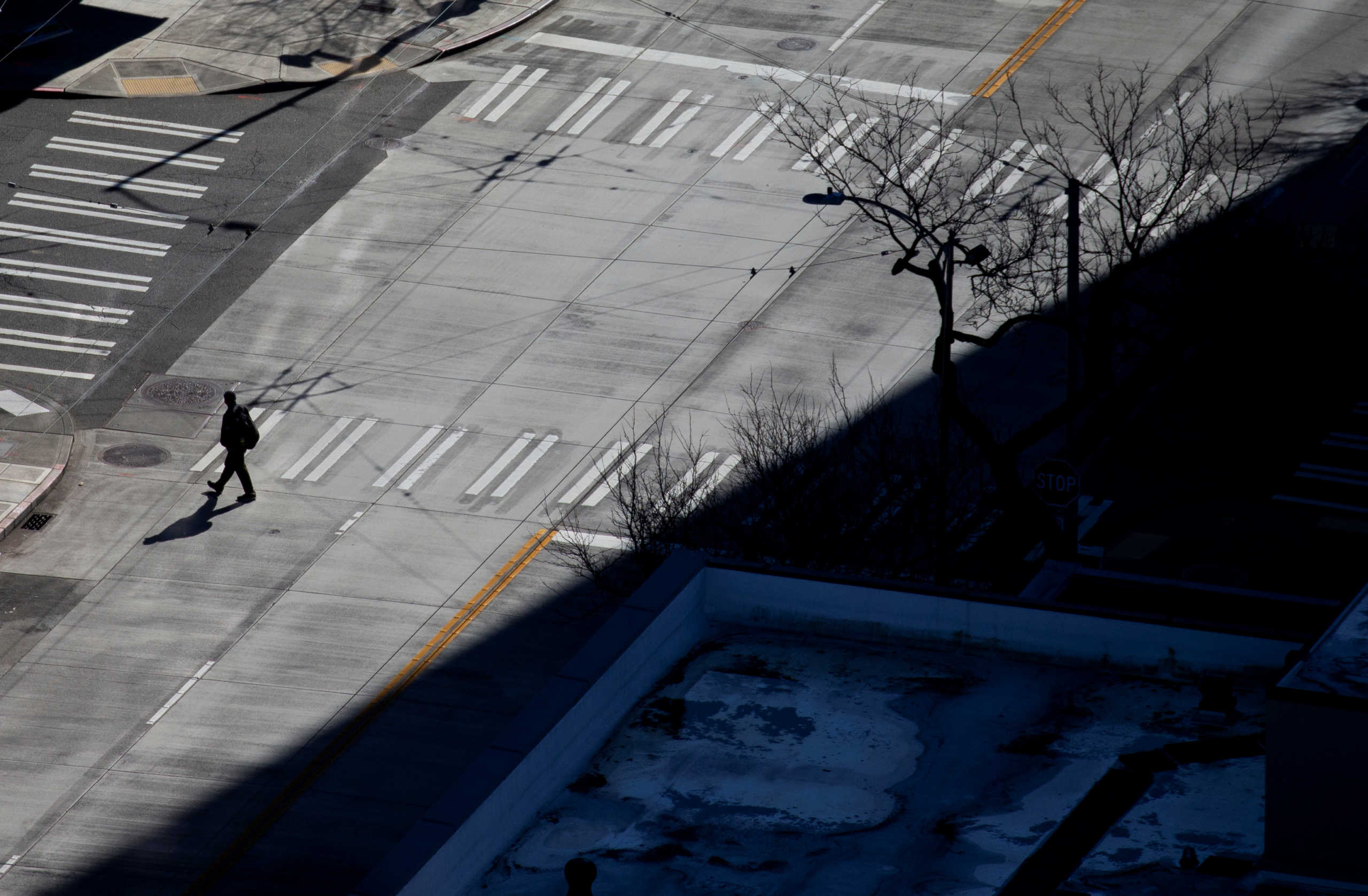 A person walks across an empty street in downtown during the outbreak of coronavirus disease (COVID-19), in Seattle, Washington, U.S., March 16, 2020. Picture taken March 16, 2020.  REUTERS