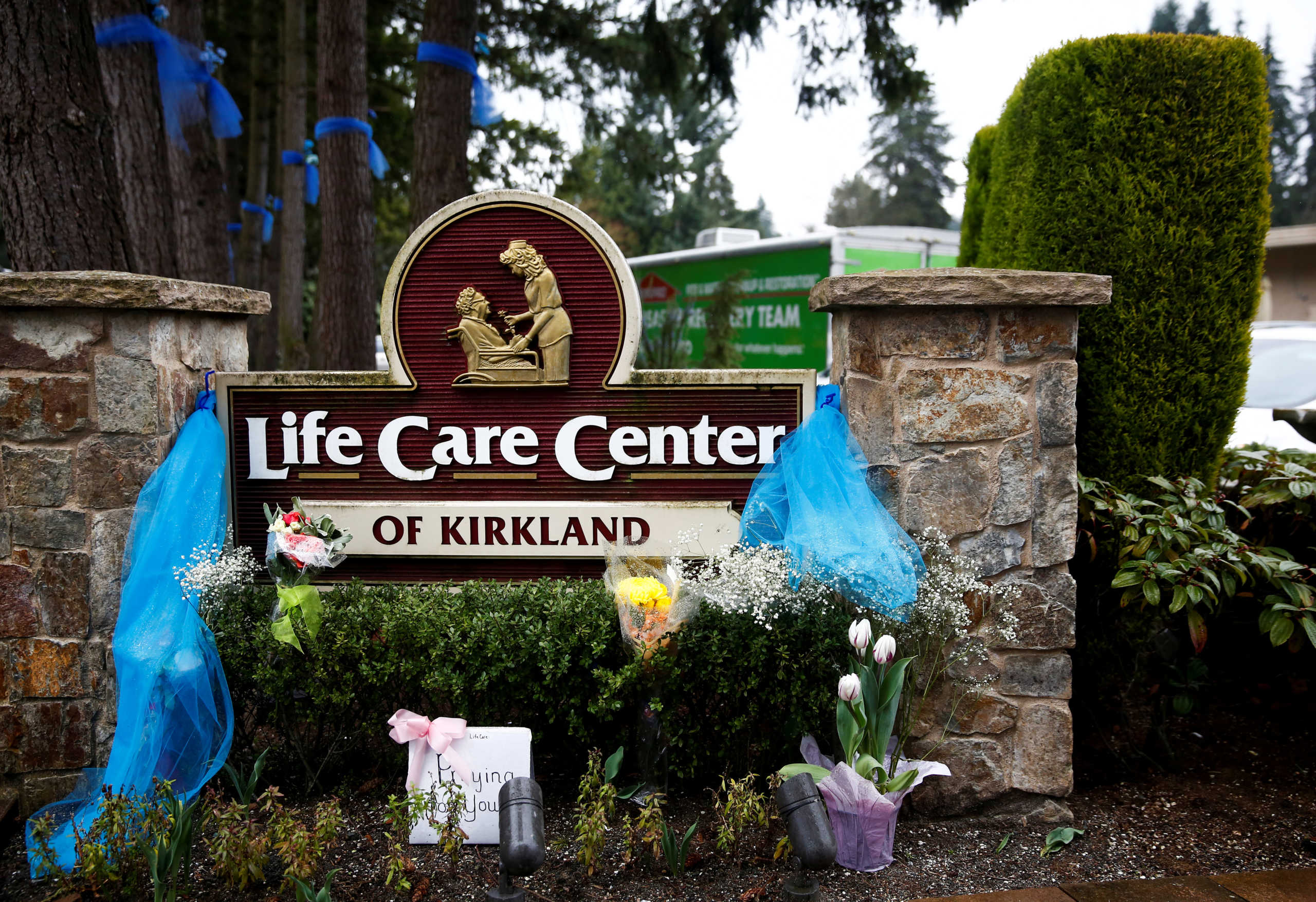 FILE PHOTO: Flowers are seen near the sign outside at the Life Care Center of Kirkland, a long-term care facility linked to several confirmed coronavirus cases, in Kirkland, Washington, U.S. March 13, 2020.  REUTERS