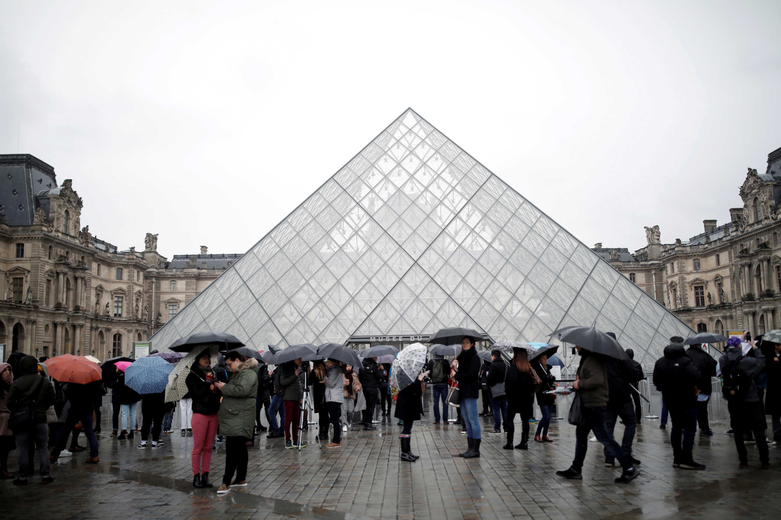 FILE PHOTO: Tourists queue to enter the Louvre as the staff closed the museum during a staff meeting about the coronavirus outbreak, in Paris, France, March 2, 2020. REUTERS