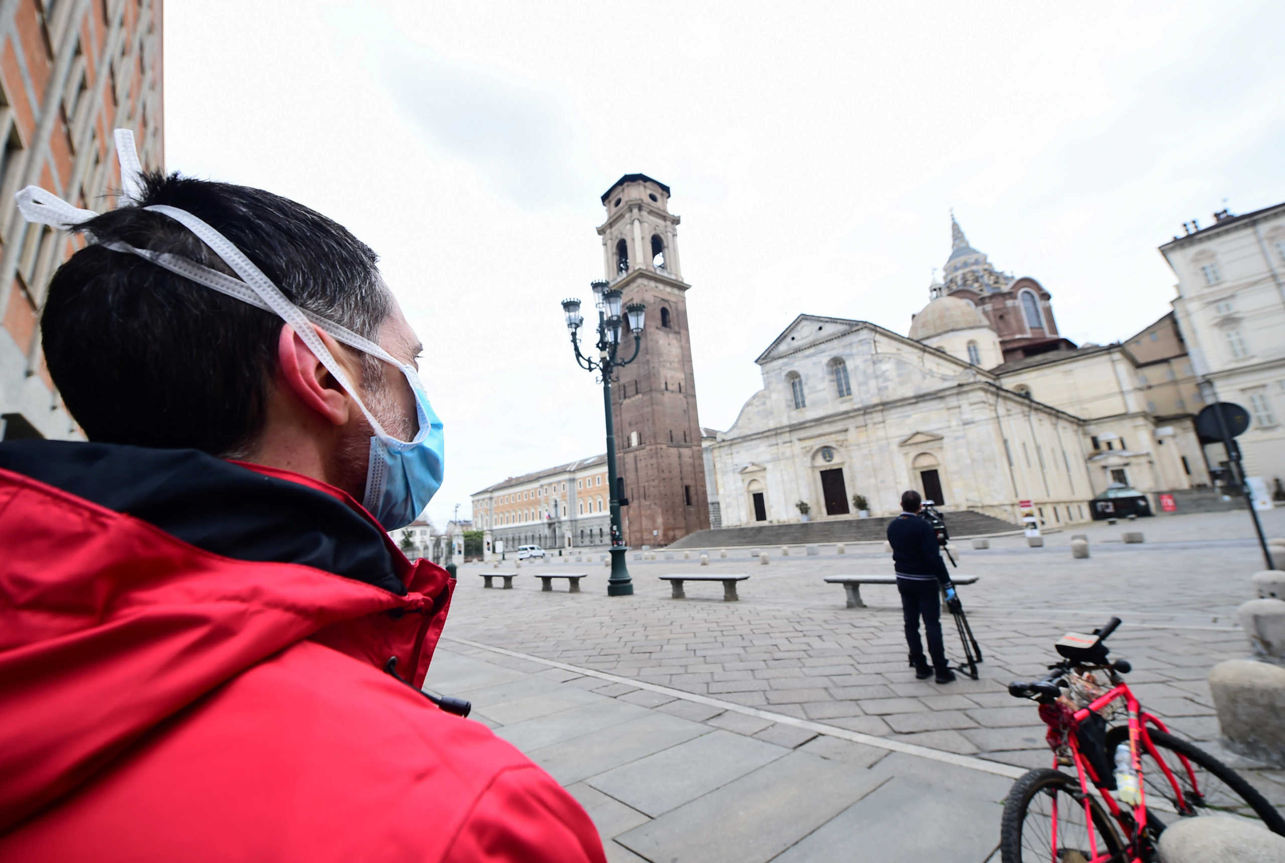 A man wearing a protective face mask looks on the Turin Cathedral, on the sixth day of an unprecedented lockdown across of all Italy imposed to slow the outbreak of coronavirus, in Turin, Italy, March 15, 2020. REUTERS