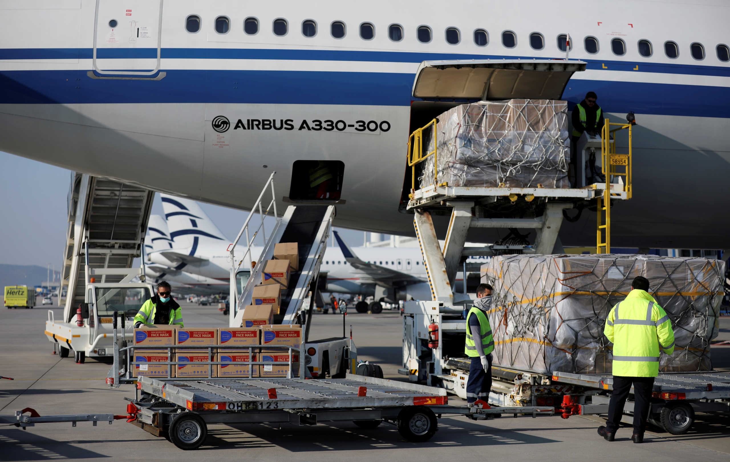 Workers unload boxes of protective face masks from an Air China plane carrying medical supplies donated by the Chinese government, in Athens, Greece, March 21, 2020. REUTERS
