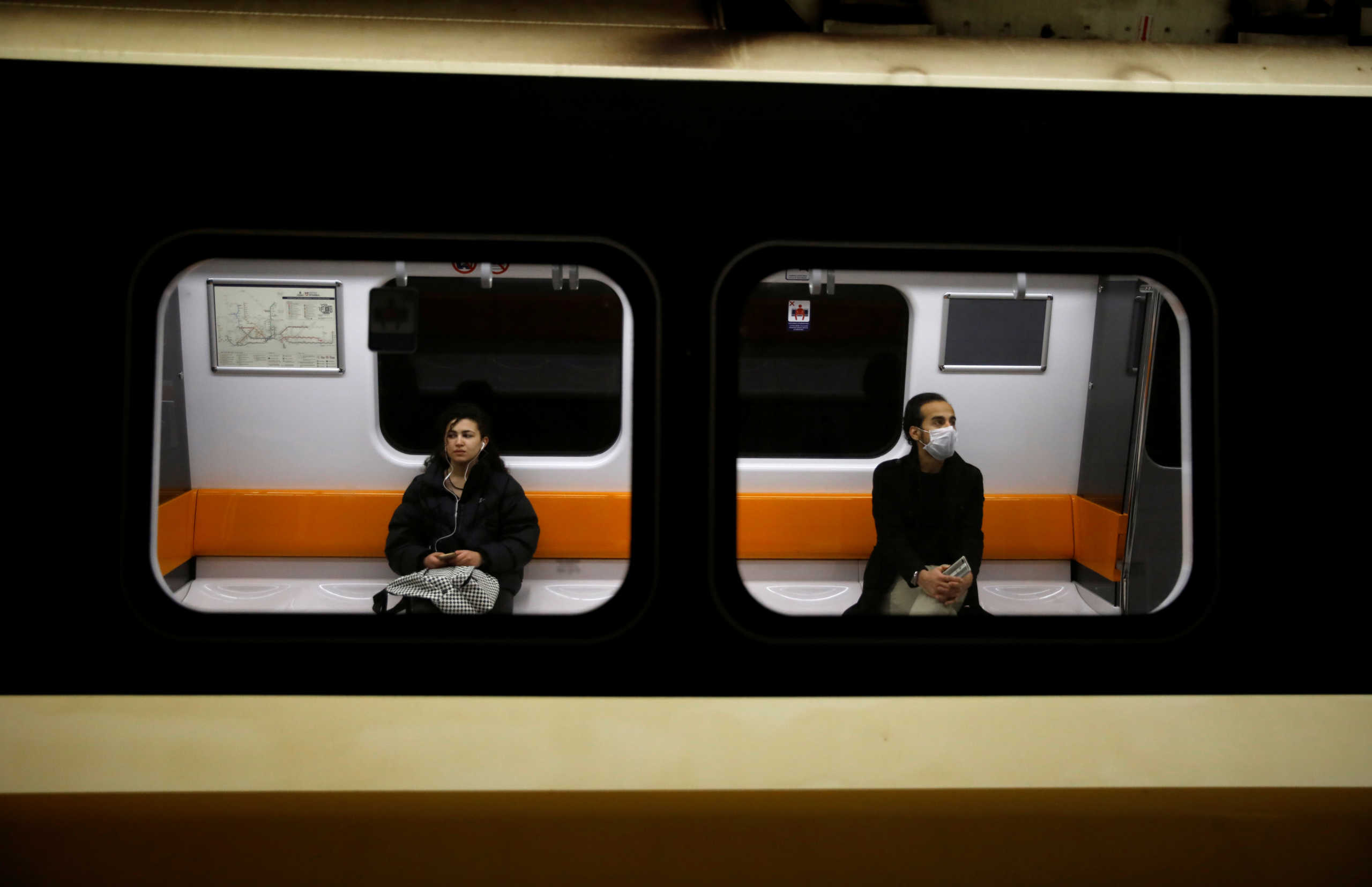 A man wearing a protective face mask and a woman are seen on a train as the spread of the coronavirus disease (COVID-19) continues, Istanbul, Turkey, March 26, 2020. REUTERS