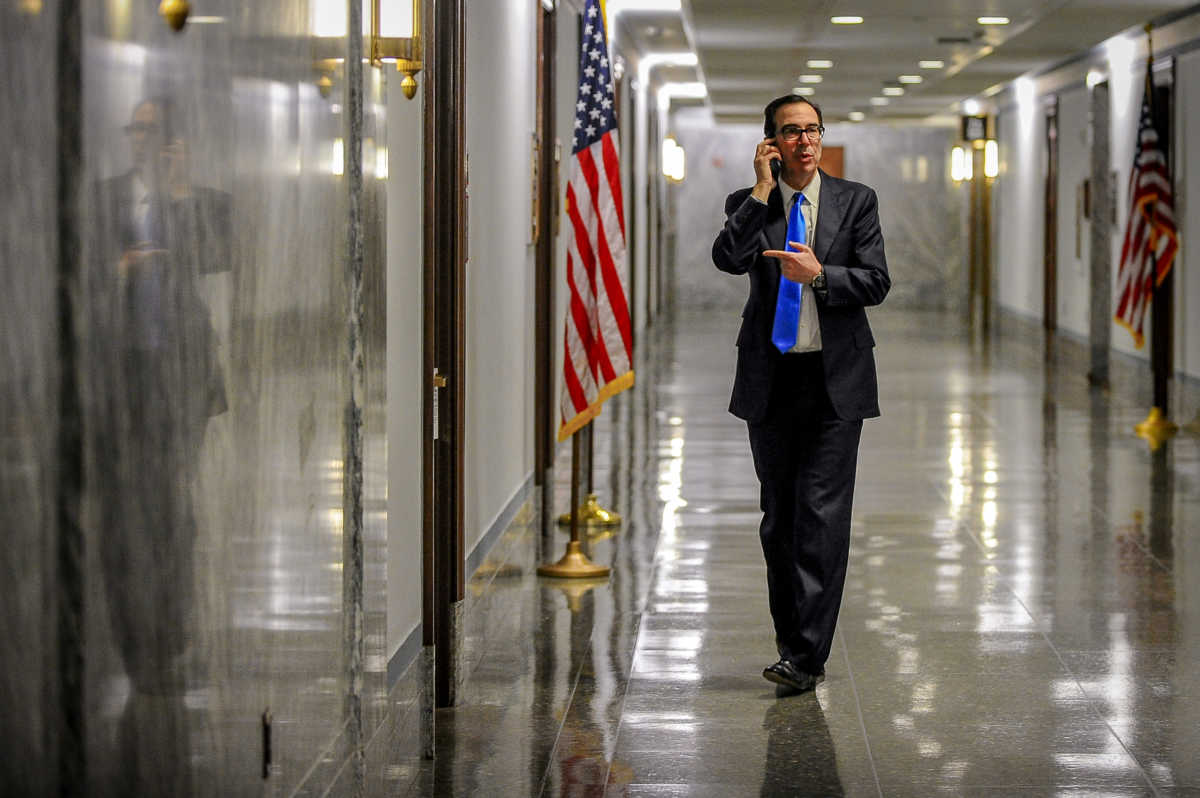 Treasury Secretary Steve Mnuchin takes a phone call in the hall outside a meeting to wrap up work on coronavirus economic aid legislation to prevent the spread of coronavirus disease (COVID-19) in Washington, U.S., March 21, 2020.      REUTERS