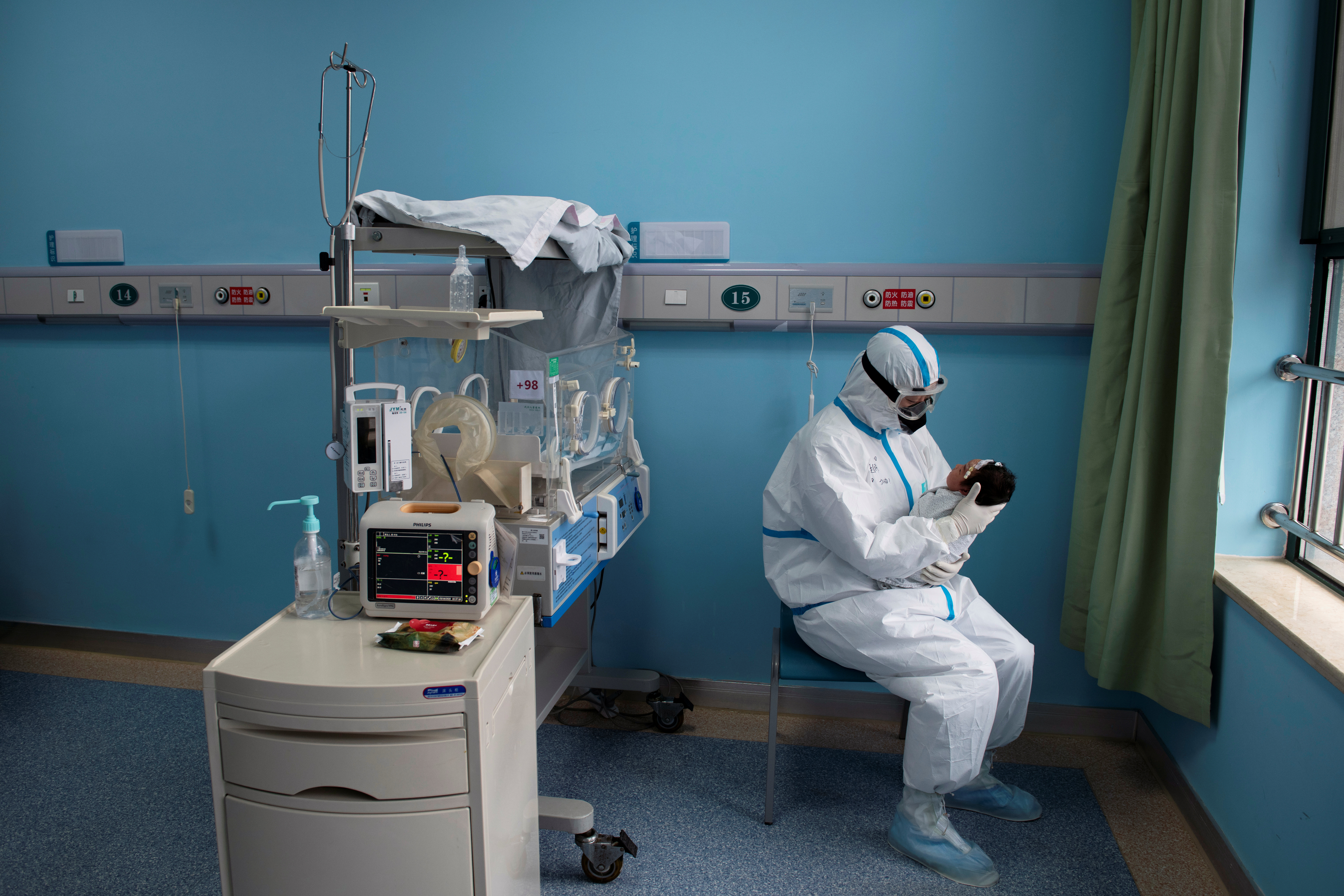 A nurse in protective suit attends to a baby with COVID-19, caused by the coronavirus, at an isolation ward of Wuhan Children's Hospital in Wuhan, Hubei province, China March 16, 2020. Picture taken March 16, 2020. China Daily via REUTERS  ATTENTION EDITORS - THIS IMAGE WAS PROVIDED BY A THIRD PARTY. CHINA OUT.