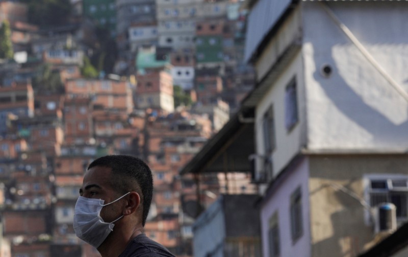 A man wearing a protective mask outside Rocinha Slum waits for a public bus during the coronavirus disease (COVID-19) outbreak in Rio de Janeiro, Brazil, March 18, 2020. REUTERS
