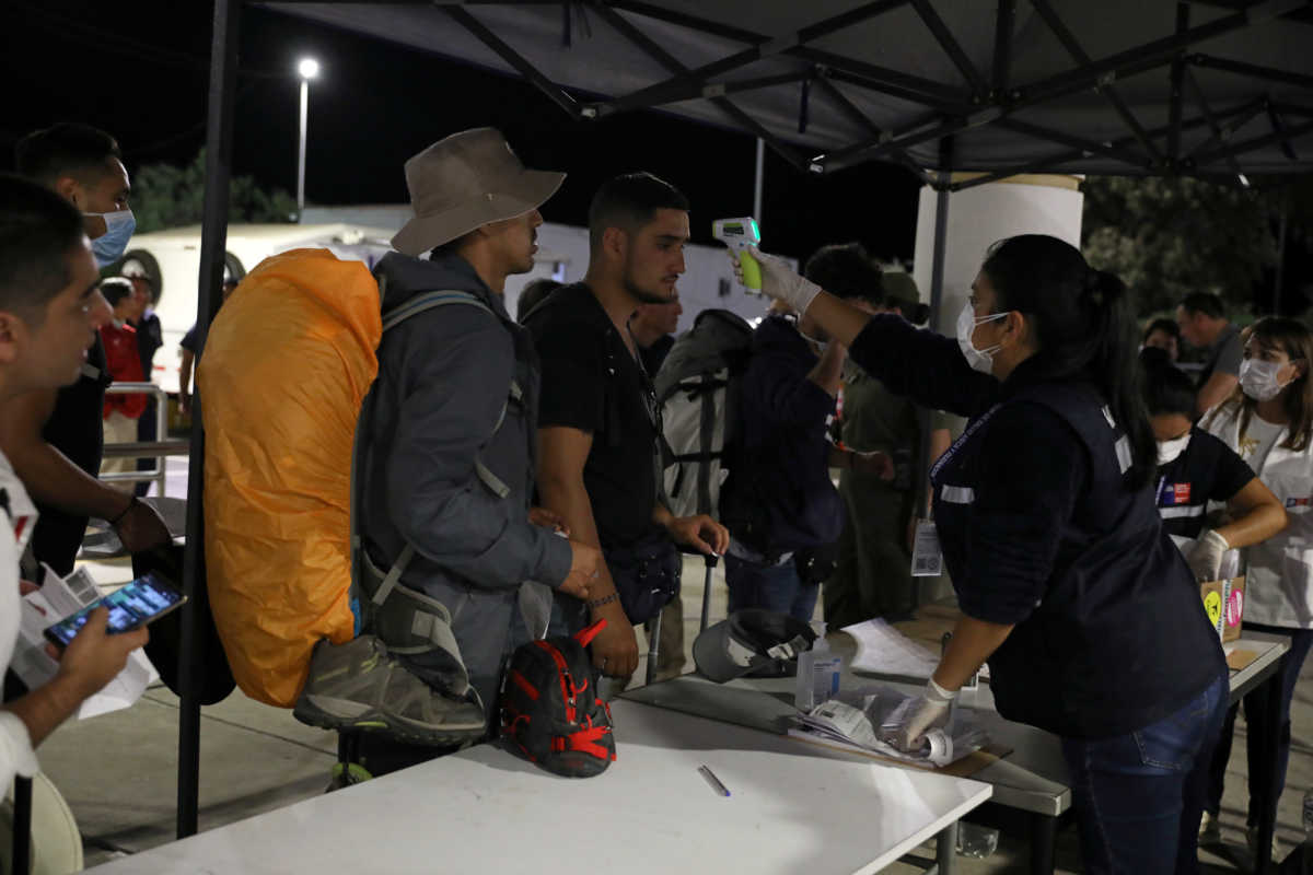 A custom worker checks person's temperature at the border between Chile and Peru, after Chile's government's announcement of the border closure in a bid to slow the spread of coronavirus disease (COVID-19), at Chacalluta check point, Arica, Chile, March 17, 2020. Picture taken March 17, 2020. REUTERS