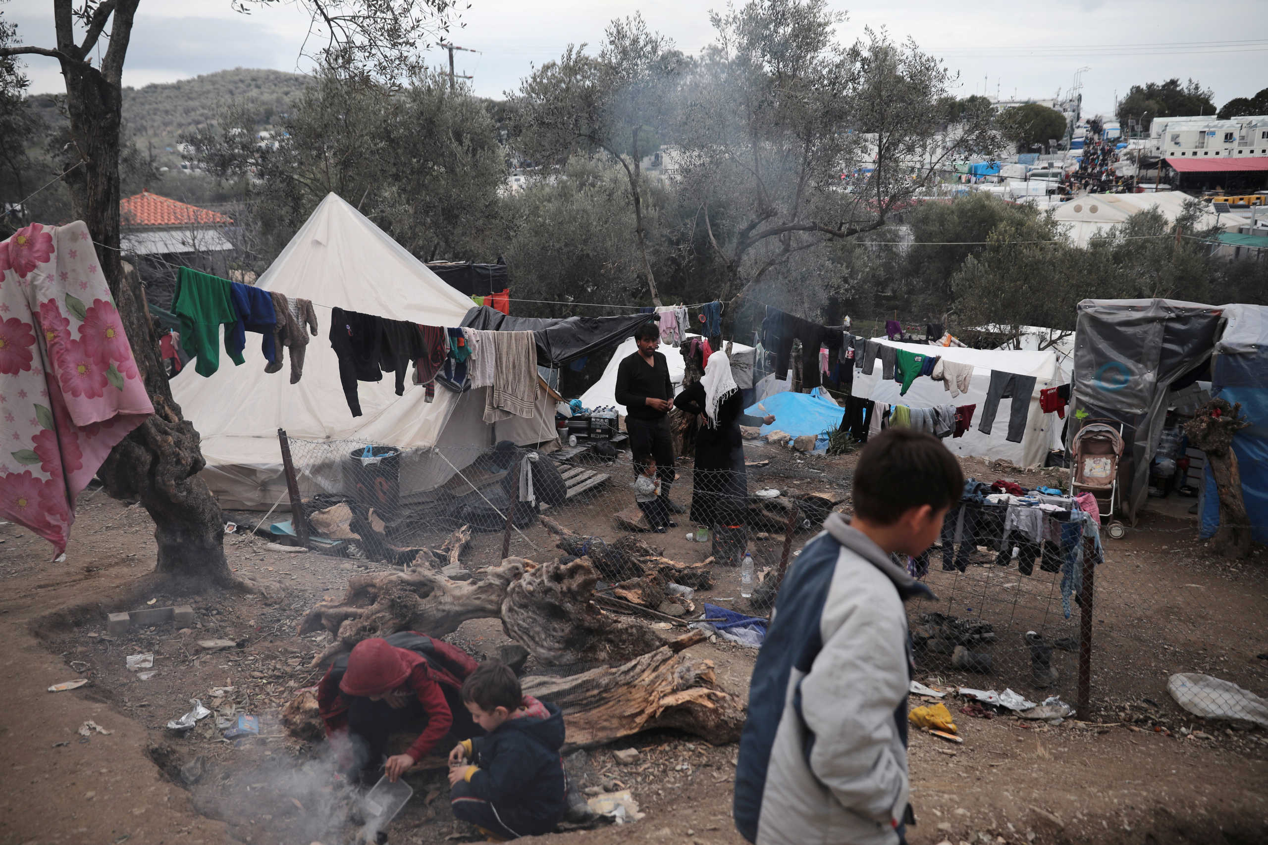 Migrants are seen at a makeshift camp for refugees and migrants next to the Moria camp, on the island of Lesbos, Greece, March 7, 2020. REUTERS