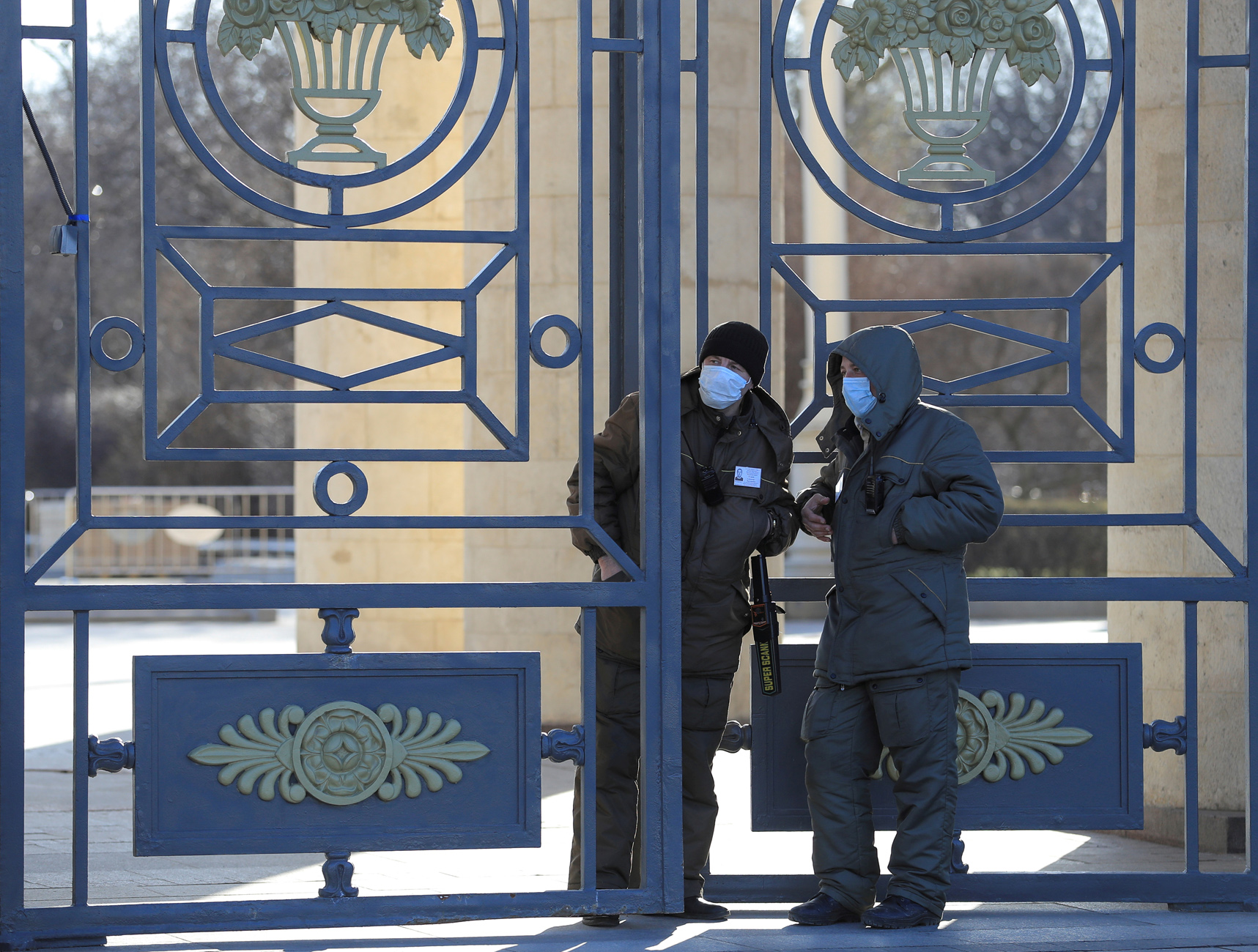 FILE PHOTO: Security guards, wearing protective masks as a preventive measure against coronavirus disease (COVID-19), stand near the gate of the Gorky Central Park of Culture and Leisure in Moscow, Russia March 26, 2020. REUTERS