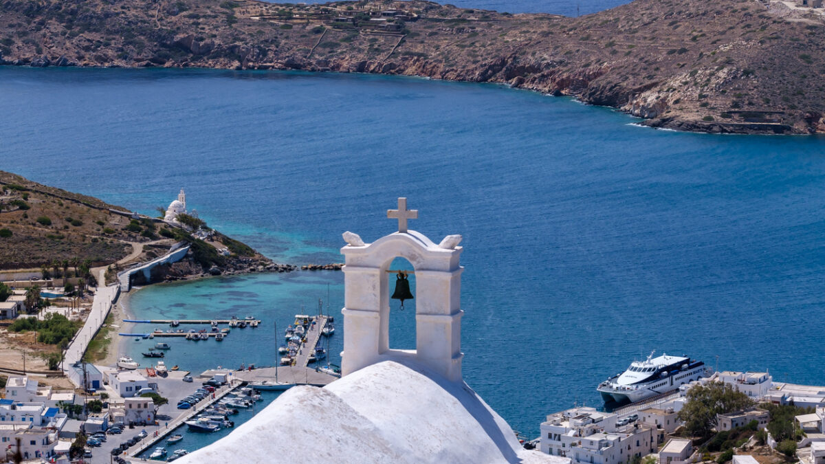 Breathtaking panoramic view of the port of Ios Greece from the rooftop of a whitewashed orthodox