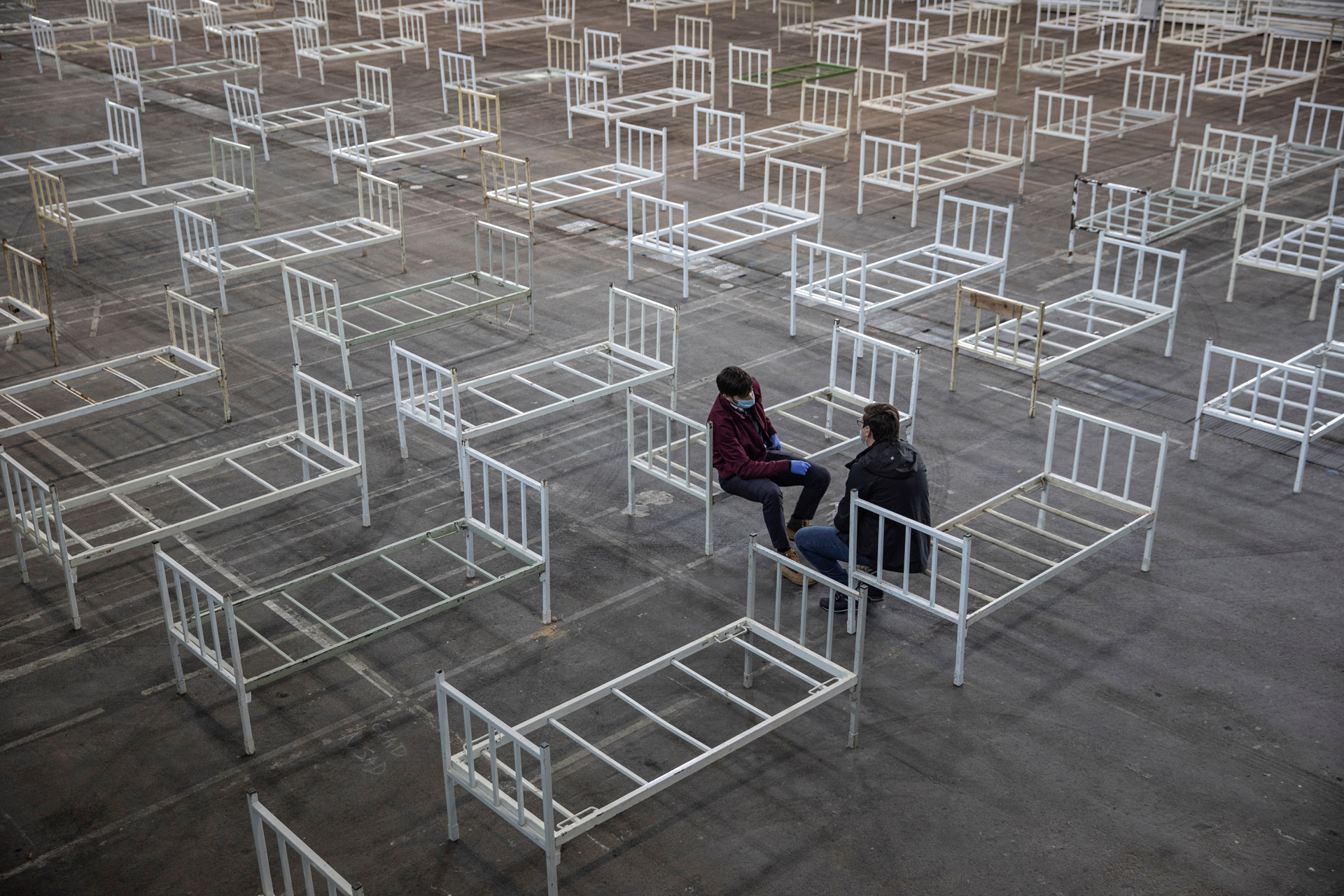 Volunteers take a break as they set up beds inside the Novi Sad Fair to accommodate people who suffer mild symptoms of coronavirus disease (COVID-19) in Novi Sad, Serbia, March 27, 2020. REUTERS