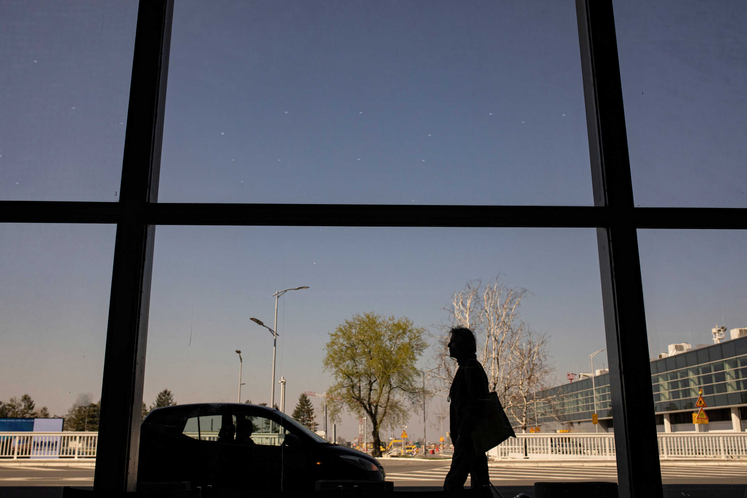 A passenger walks outside as Serbia halts all commercial flights from Belgrade's Nikola Tesla airport to prevent the spread of coronavirus disease (COVID-19) in Belgrade, Serbia, March 19, 2020. REUTERS