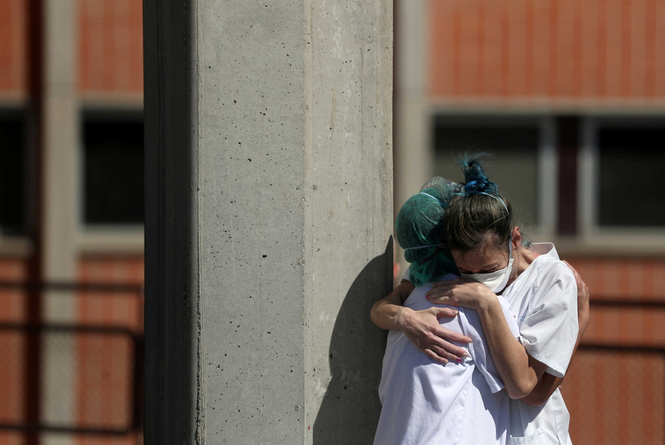 Medical wokers hug eachother outside the emergency rooms at Severo Ochoa Hospital during the coronavirus disease (COVID-19) outbreak in Leganes, Spain, March 26, 2020. REUTERS
