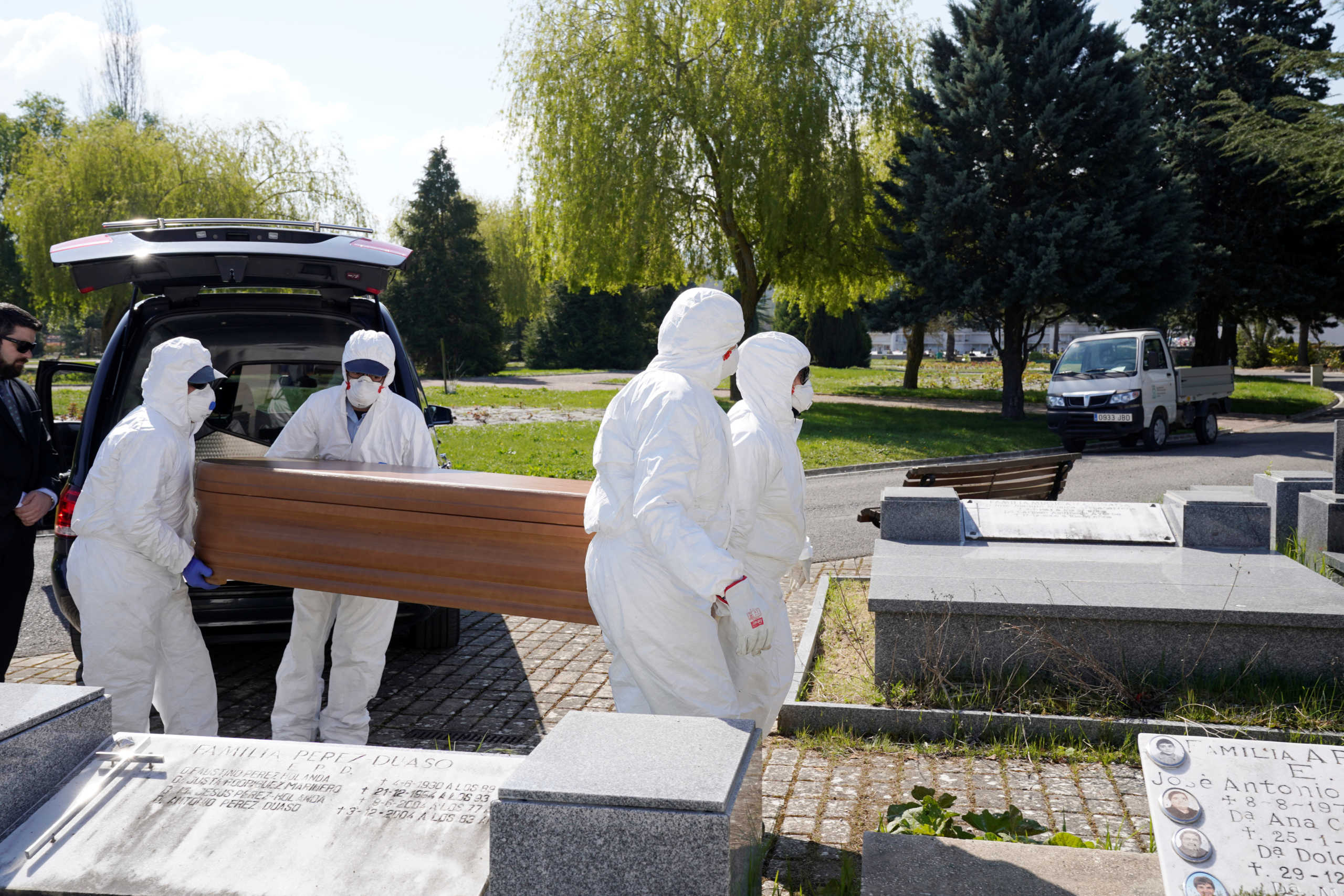 Municipal workers wearing protective gear carry the coffin of a victim of the coronavirus disease (COVID-19) at El Salvador cemetery in Vitoria, Spain, March 27, 2020. REUTERS