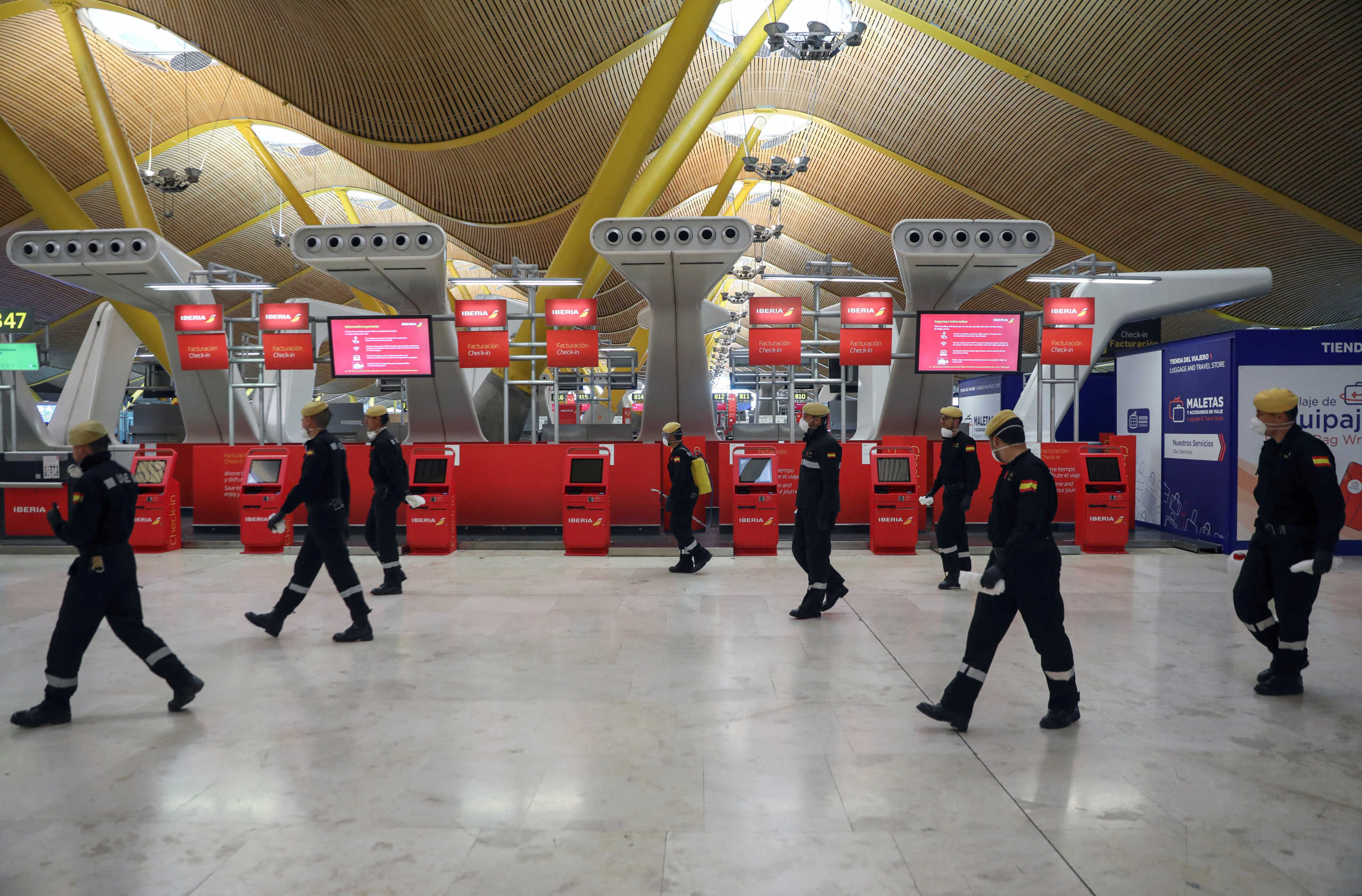Military Emergency Unit members walk at Madrid's Adolfo Suarez Barajas Airport during a disinfection and a partial lockdown, as part of a 15-day state of emergency to combat the coronavirus disease (COVID-19) outbreak in Madrid, Spain March 19, 2020. REUTERS