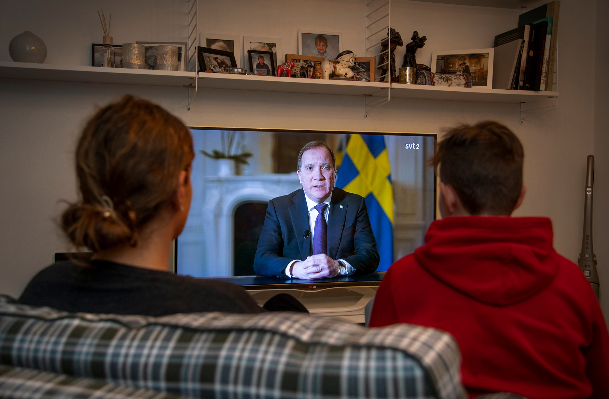 People watch TV as Sweden's Prime Minister Stefan Lofven addresses the nation on coronavirus crisis during a broadcast on Swedish national public television, in Stockholm, Sweden March 22, 2020. TT News Agency