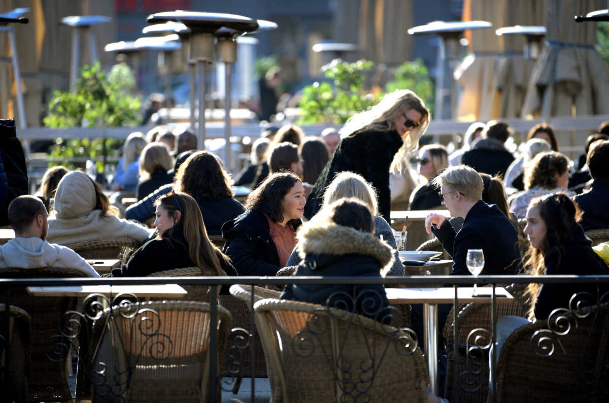 People enjoy the sun at an outdoor restaurant, despite the continuing spread of coronavirus disease (COVID-19), in Stockholm, Sweden March 26, 2020. TT News Agency
