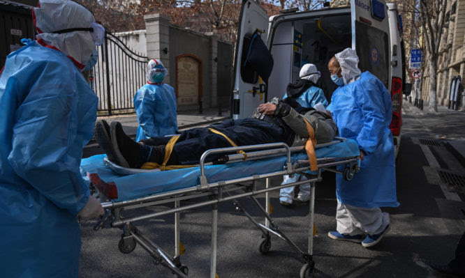 TOPSHOT - Medical staff in protective clothes are seen carrying a patient from an apartment suspected of having the virus in Wuhan, in Hubei province on January 30, 2020. - The World Health Organization, which initially downplayed the severity of a disease that has now killed 170 nationwide, warned all governments to be "on alert" as it weighed whether to declare a global health emergency. (Photo by Hector RETAMAL