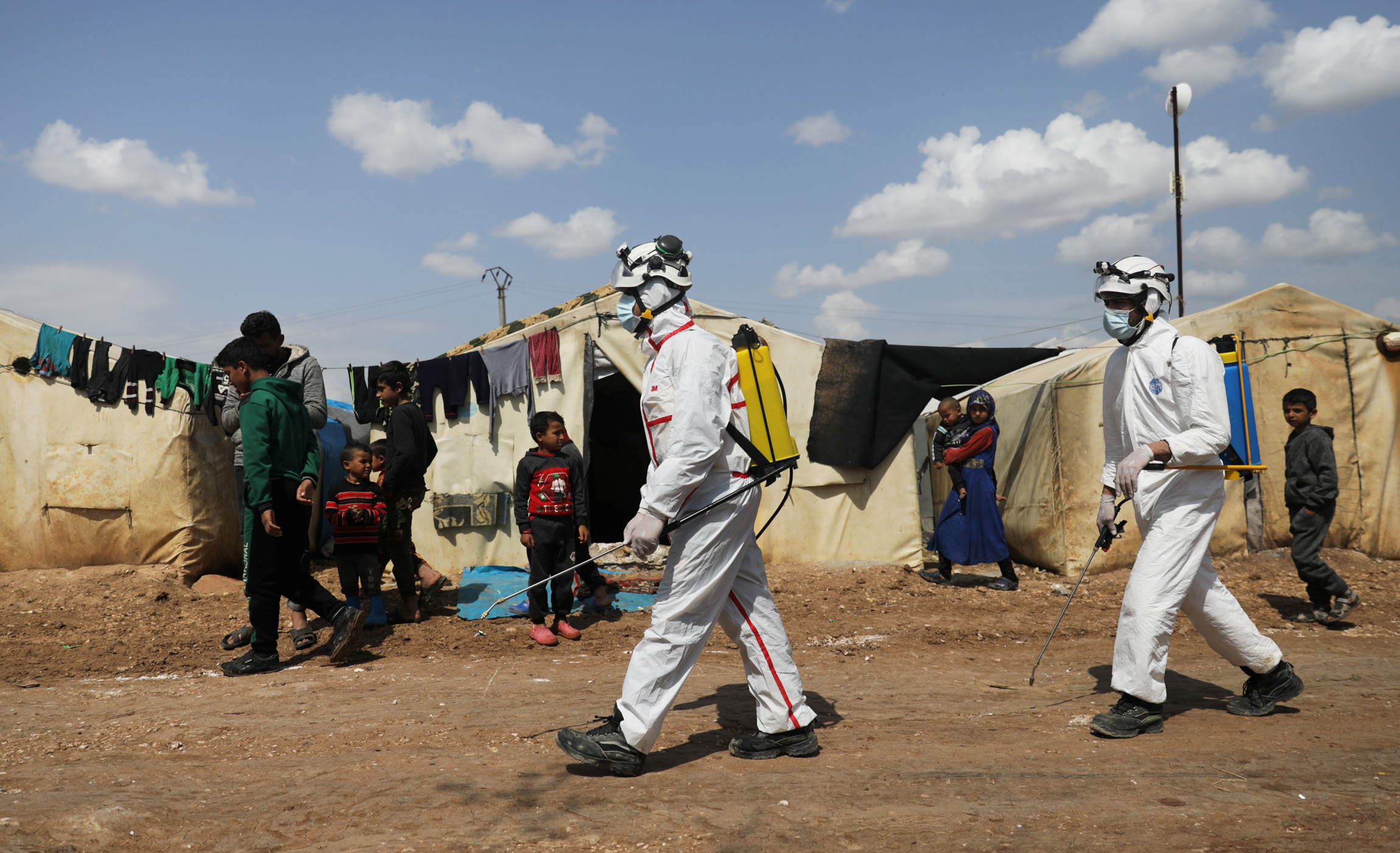 Members of the Syrian Civil defence sanitize the Bab Al-Nour internally displaced persons camp, to prevent the spread of coronavirus disease (COVID-19) in Azaz, Syria March 26, 2020. REUTERS